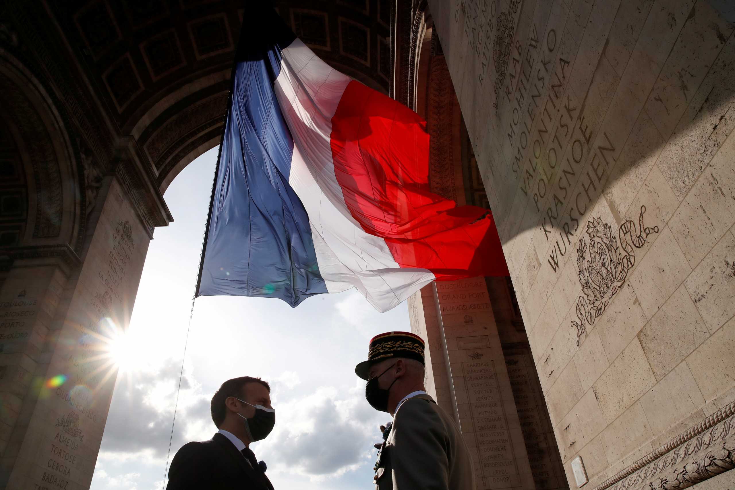 French President Emmanuel Macron speaks with General Francois Lecointre during a ceremony to mark the end of World War II at the Arc de Triomphe in Paris, France May 8, 2021. REUTERS