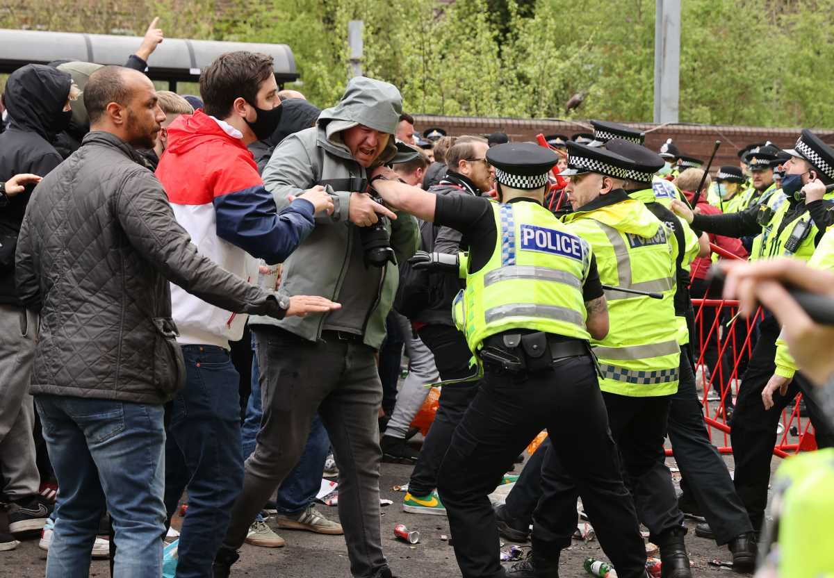 Soccer Football - Manchester United fans protest against their owners before the Manchester United v Liverpool Premier League match - Old Trafford, Manchester, Britain - May 2, 2021 Manchester United fans clash with police officers in protest against their owners outside the stadium before the match Action Images via REUTERS