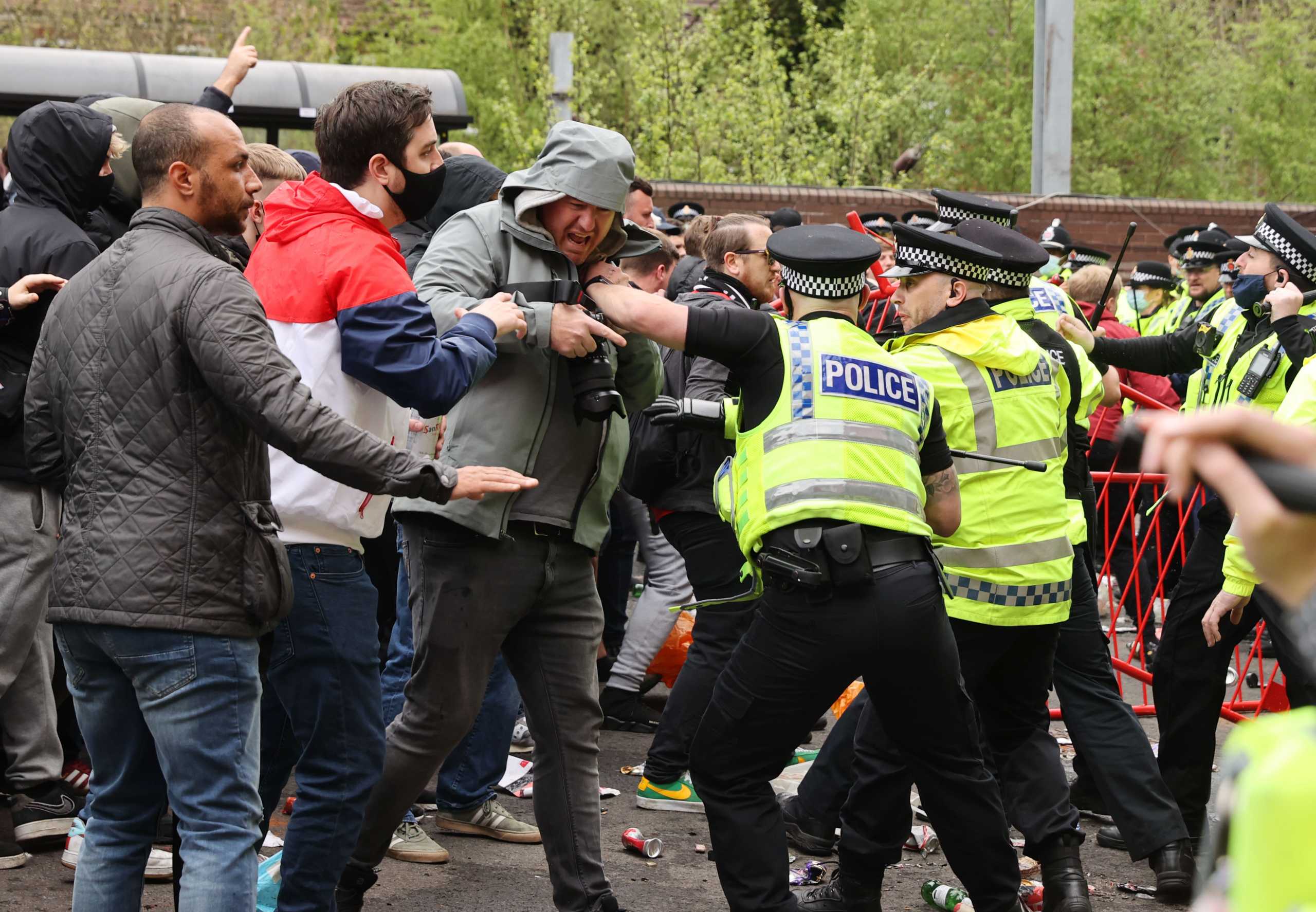 Soccer Football - Manchester United fans protest against their owners before the Manchester United v Liverpool Premier League match - Old Trafford, Manchester, Britain - May 2, 2021 Manchester United fans clash with police officers in protest against their owners outside the stadium before the match Action Images via REUTERS