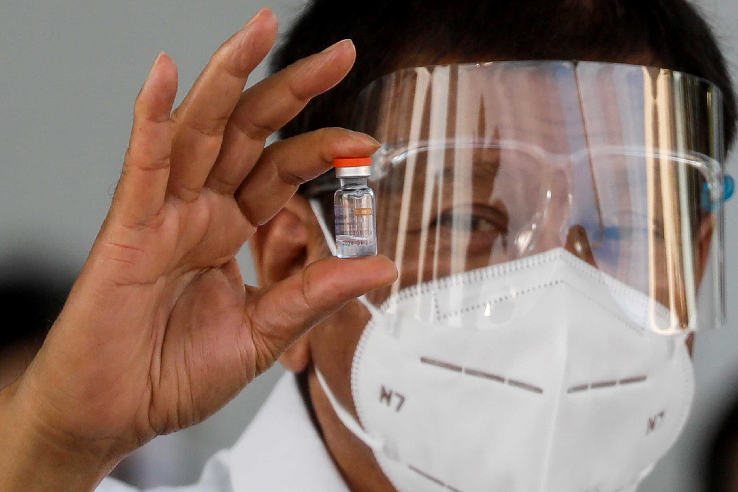 FILE PHOTO: Philippine President Rodrigo Duterte holds a vial of Sinovac Biotech's CoronaVac as the first shipment of coronavirus disease (COVID-19) vaccine arrives in the country, at Villamor Air Base, Pasay, Metro Manila, Philippines, February 28, 2021. REUTERS