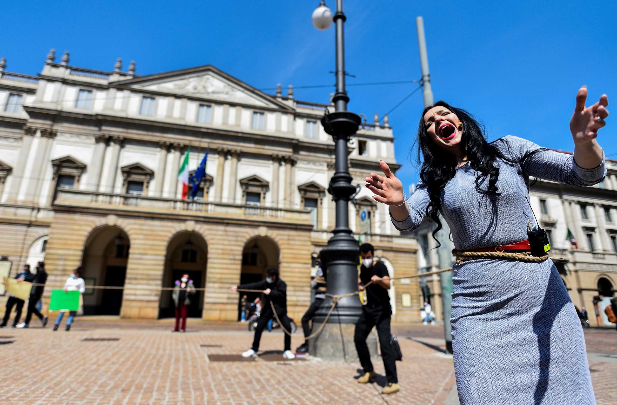 Opera singer performs the first act of Giacomo Puccini's famed romance opera 'La Boheme' outside the La Scala theatre as part of a protest against the entertainment sector's crisis caused by the coronavirus disease (COVID-19) pandemic and restrictions, in Milan, Italy April 20, 2021. REUTERS