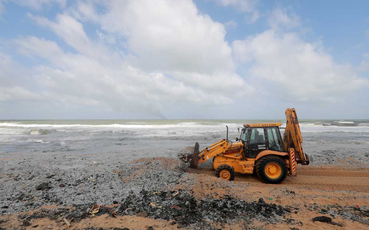A backhoe loader collects debris washed off to a beach from the MV X-Press Pearl container ship, which caught fire off the Colombo Harbour, on a beach in Ja-Ela, Sri Lanka May 28, 2021. REUTERS