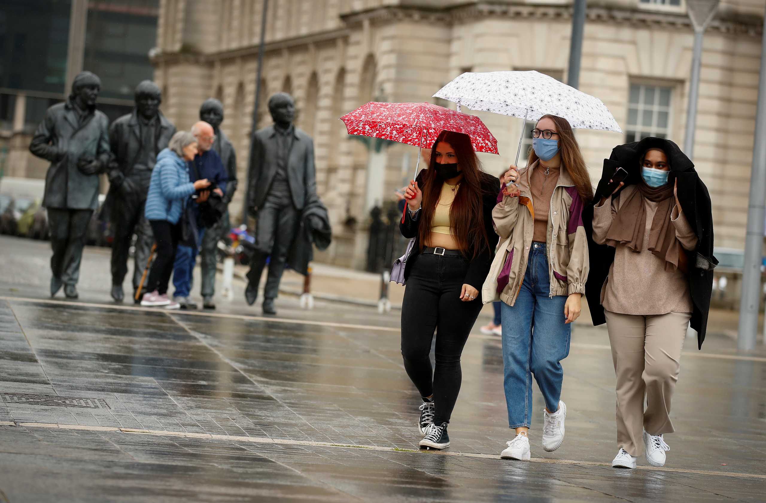 Students Sophie Langford, Emily Campbell and Tamzida Begun walk to the mass vaccine centre at Liverpool Pier Head that is offering walk in visits for the coronavirus (COVID-19) vaccine in Liverpool, Britain, June 23, 2021.  REUTERS