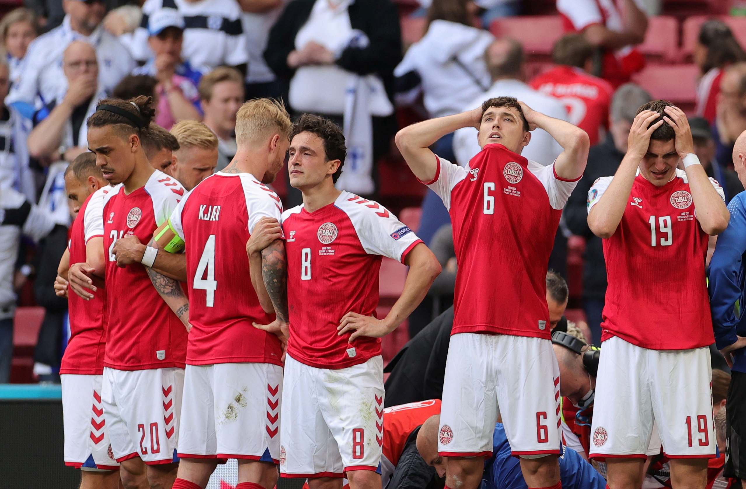 Soccer Football - Euro 2020 - Group B - Denmark v Finland - Parken Stadium, Copenhagen, Denmark - June 12, 2021 Denmark players react as Christian Eriksen receives medical attention after collapsing during the match Pool via REUTERS
