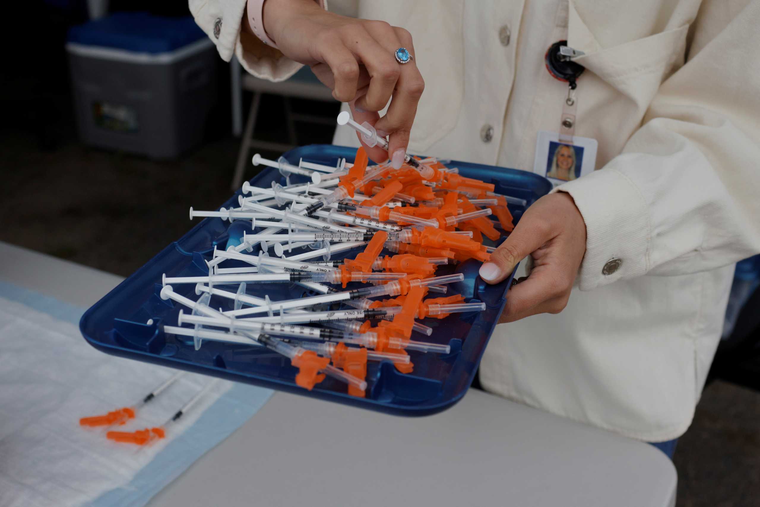 A doctor puts out syringes with the Pfizer vaccine at a coronavirus disease (COVID-19) vaccine clinic aimed at youths ages 12 or older at La Colaborativa in Chelsea, Massachusetts, U.S., June 11, 2021.   REUTERS