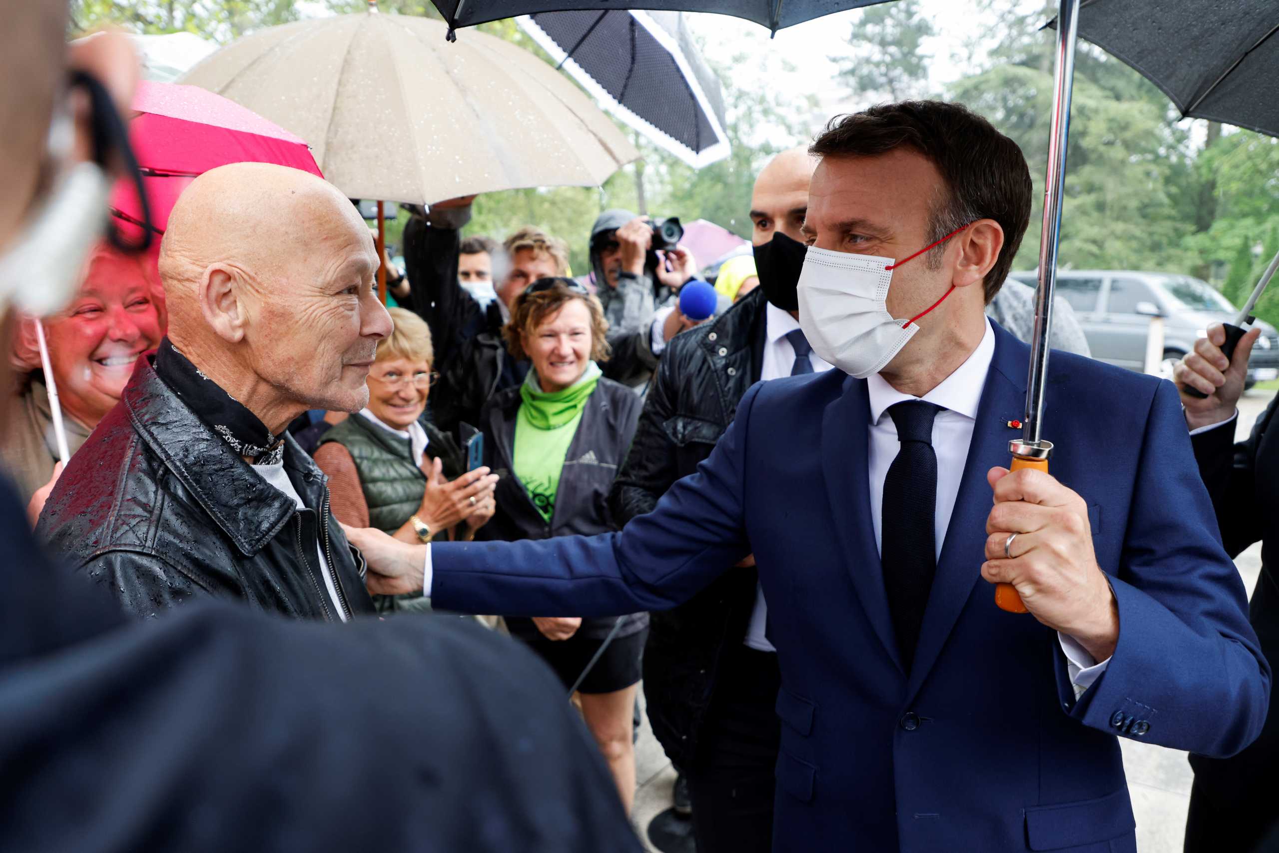French President Emmanuel Macron talks with a friend outside a polling station in Le Touquet, France during the second round of regional elections on June 27, 2021. Ludovic Marin