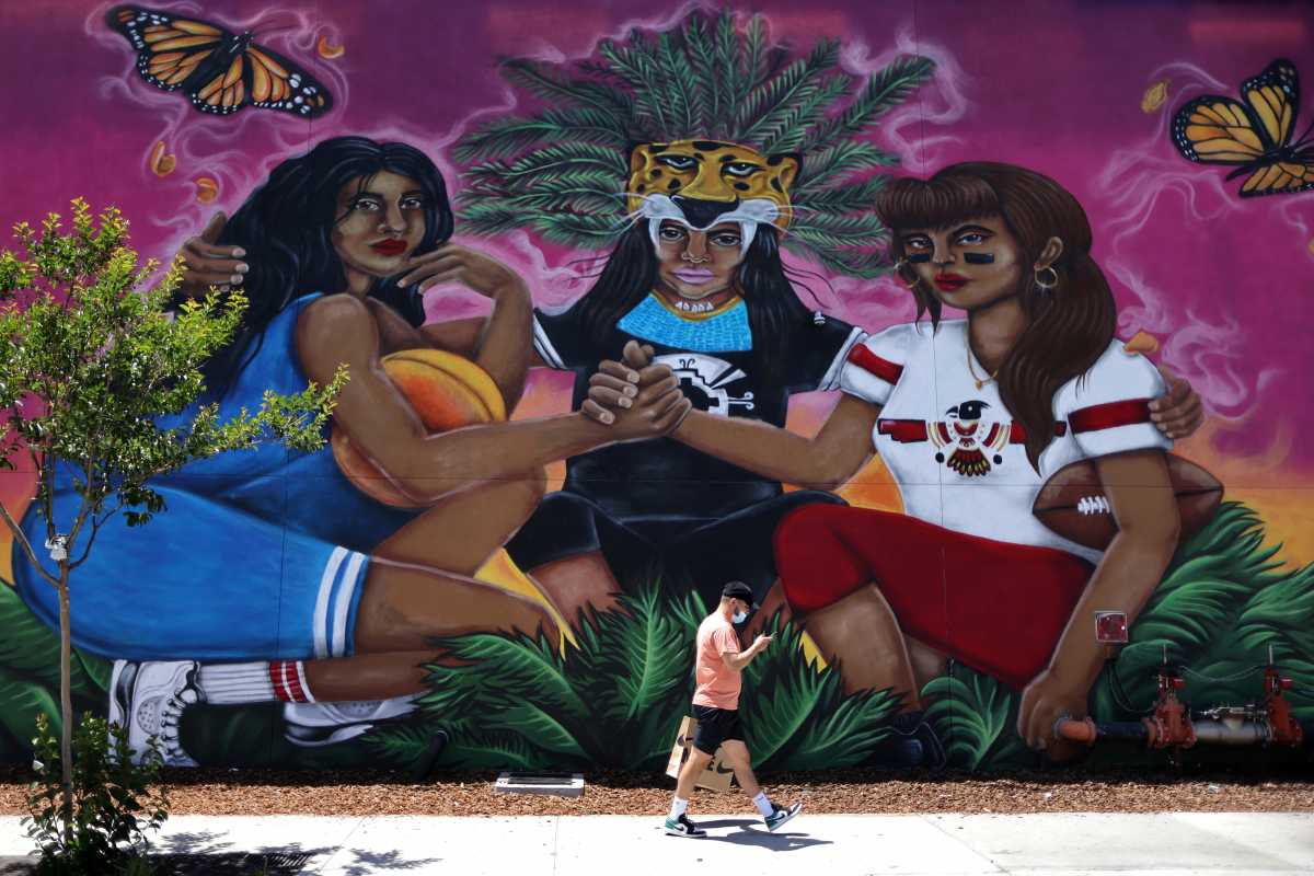 A man walks past a mural, as the coronavirus (COVID-19) disease continues, in East Los Angeles, California, U.S., May 26, 2021. REUTERS