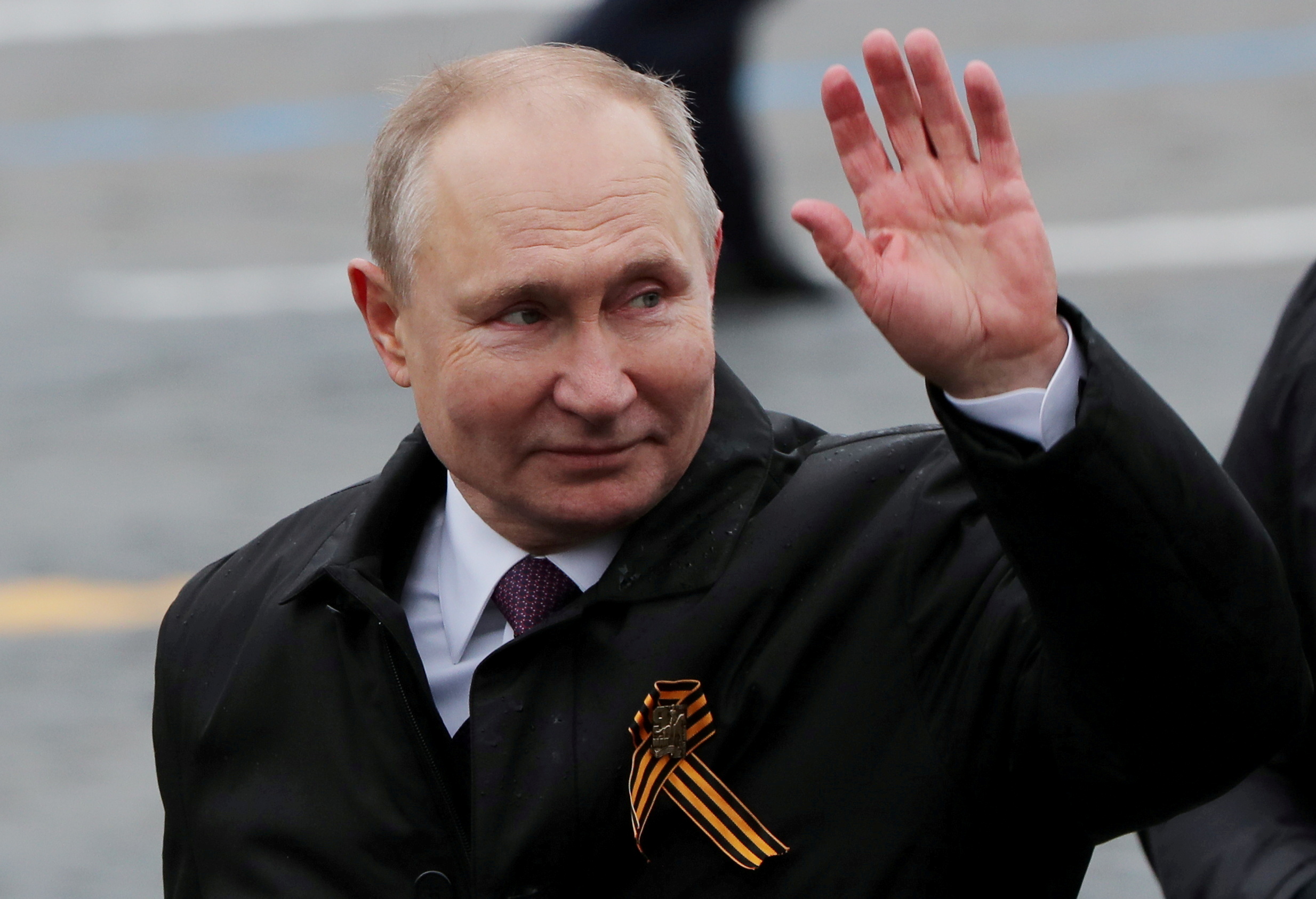 FILE PHOTO: Russian President Vladimir Putin waves while walking along Red Square after a military parade on Victory Day, in central Moscow, Russia May 9, 2021. REUTERS