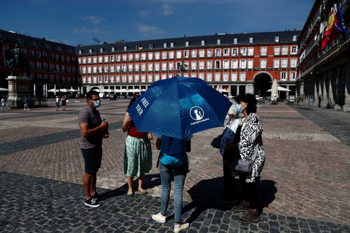 A guide talks to customers before starting a free tour at Plaza Mayor in Madrid, Spain, June 2, 2021. REUTERS