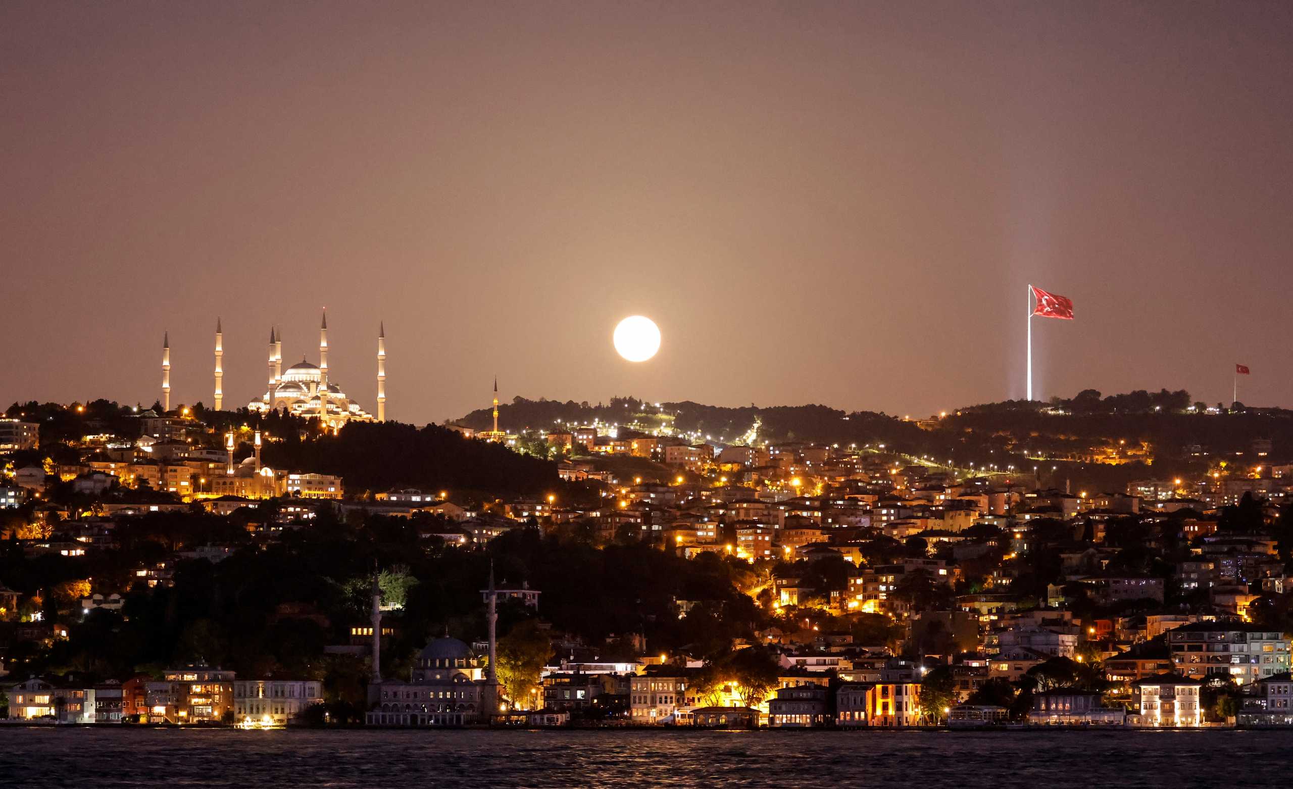 The full moon, known as the "Super Flower Moon", rises above the Camlica Mosque in Istanbul, Turkey May 26, 2021. REUTERS