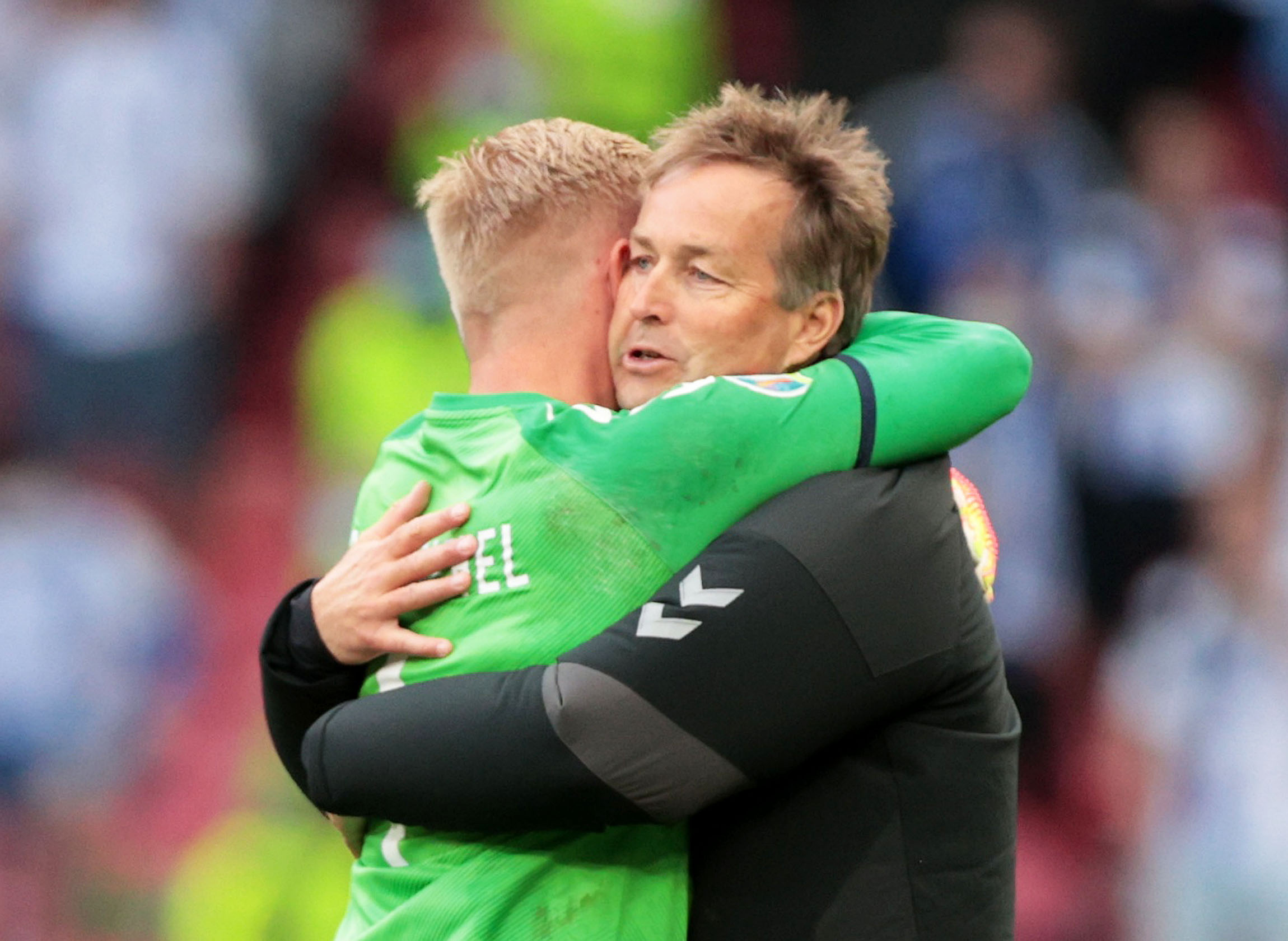 Soccer Football - Euro 2020 - Group B - Denmark v Finland - Parken Stadium, Copenhagen, Denmark - June 12, 2021 Denmark coach Kasper Hjulmand and Kasper Schmeichel embrace before the match is restarted Pool via REUTERS