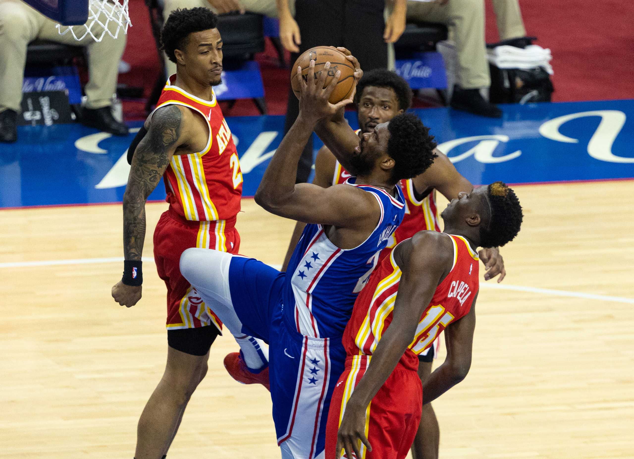 Jun 8, 2021; Philadelphia, Pennsylvania, USA; Philadelphia 76ers center Joel Embiid (21) drives for a shot past Atlanta Hawks center Clint Capela (15) and forward John Collins (20) during the first quarter in game two of the second round of the 2021 NBA Playoffs at Wells Fargo Center. Mandatory Credit: Bill Streicher-USA TODAY Sports