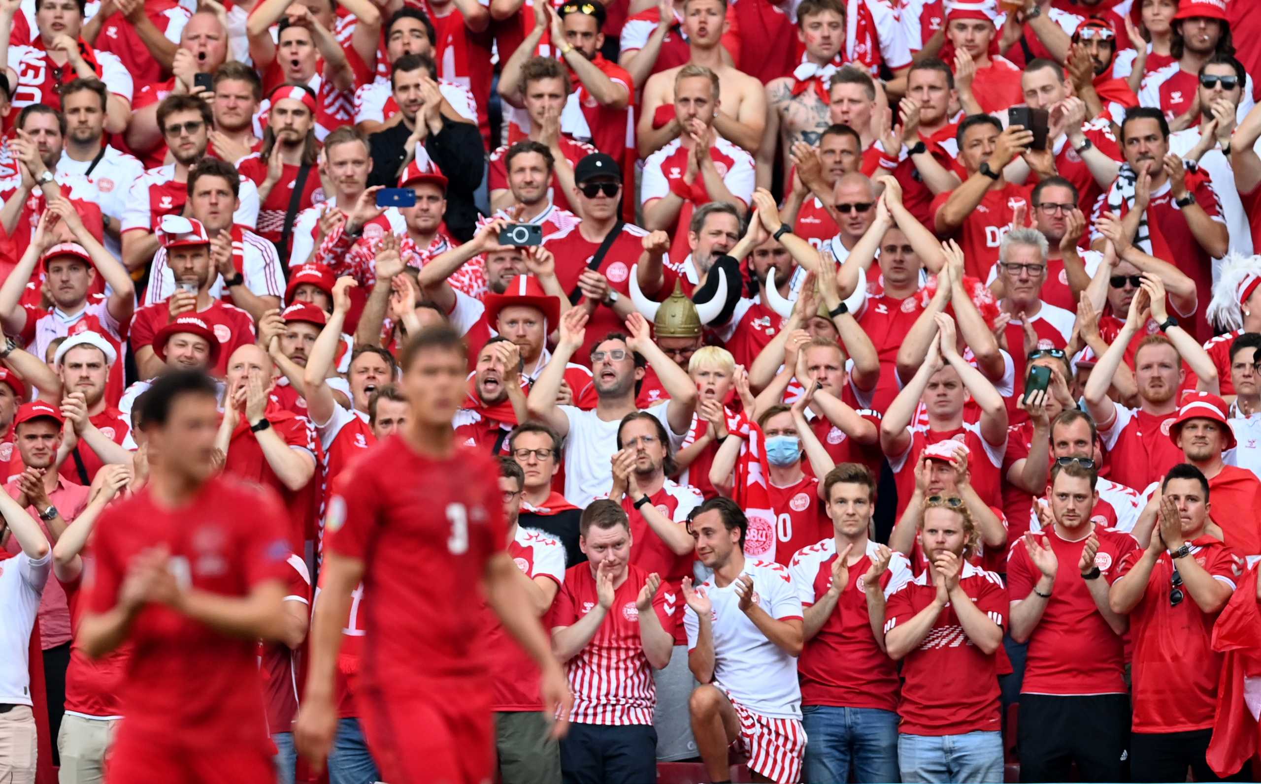 Soccer Football - Euro 2020 - Group B - Denmark v Belgium - Parken Stadium, Copenhagen, Denmark - June 17, 2021 Denmark fans react after the ball is kicked out in the 10th minute of the match to applaud Denmark's Christian Eriksen who remains in hospital after collapsing during the match between Denmark and Finland last Saturday. Pool via REUTERS