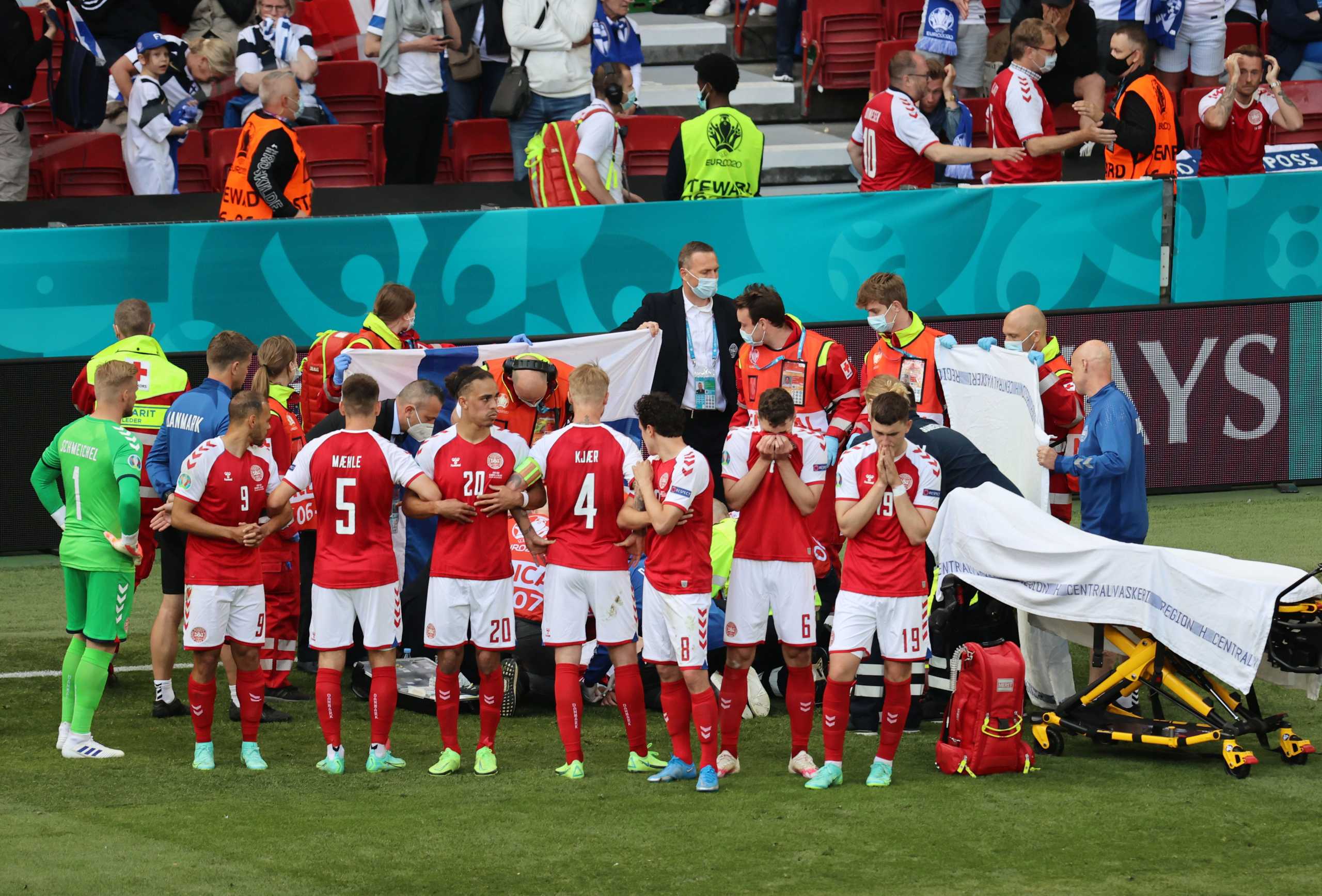 Soccer Football - Euro 2020 - Group B - Denmark v Finland - Parken Stadium, Copenhagen, Denmark - June 12, 2021 Denmark players react as Christian Eriksen receives medical attention after collapsing during the match Pool via REUTERS
