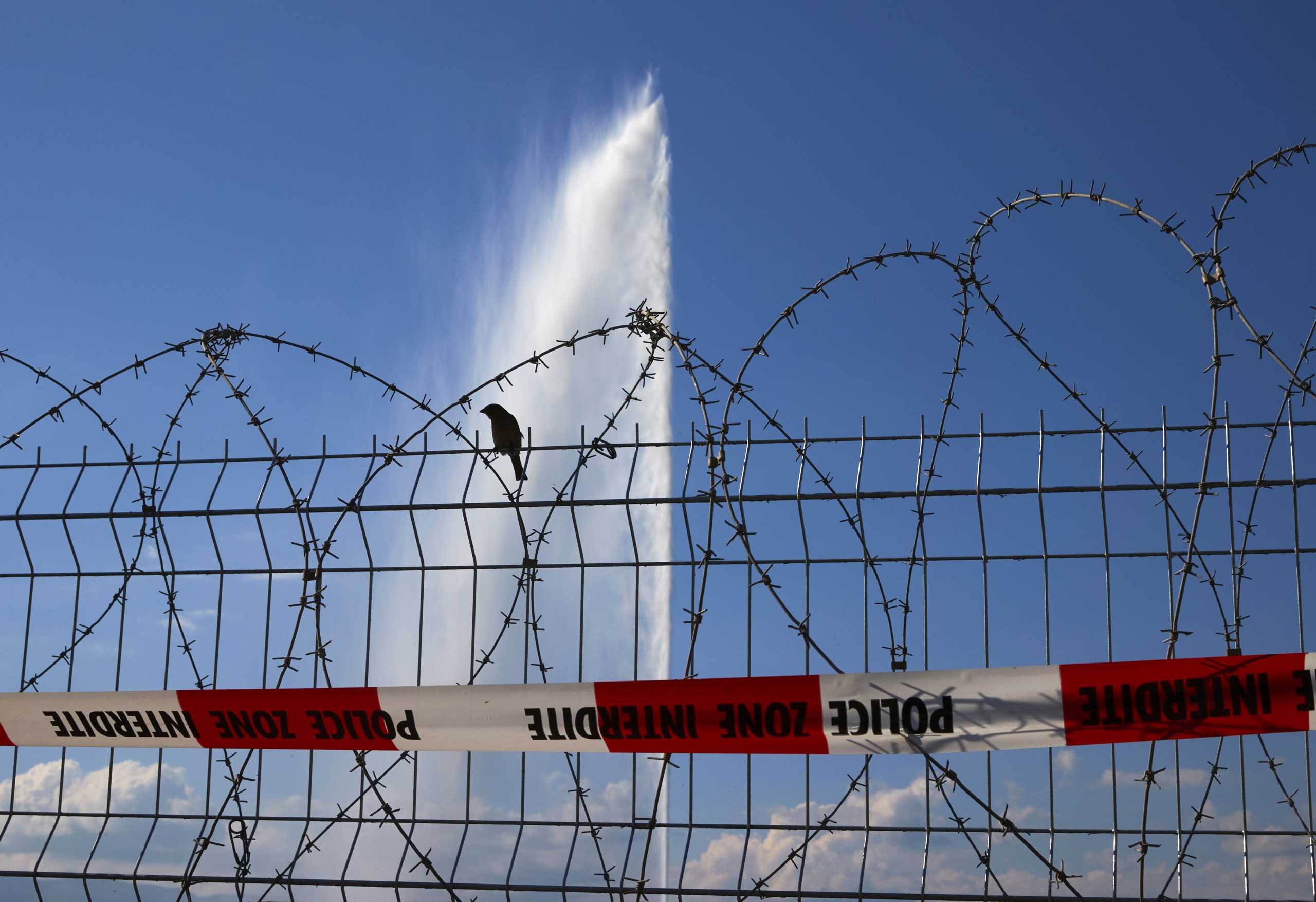 A bird sits on barbed wire in front of the Jet d'Eau fountain in Lac Leman ahead of the June 16 summit between U.S. President Joe Biden and Russian President Vladimir Putin in Geneva, Switzerland, June 14, 2021. REUTERS
