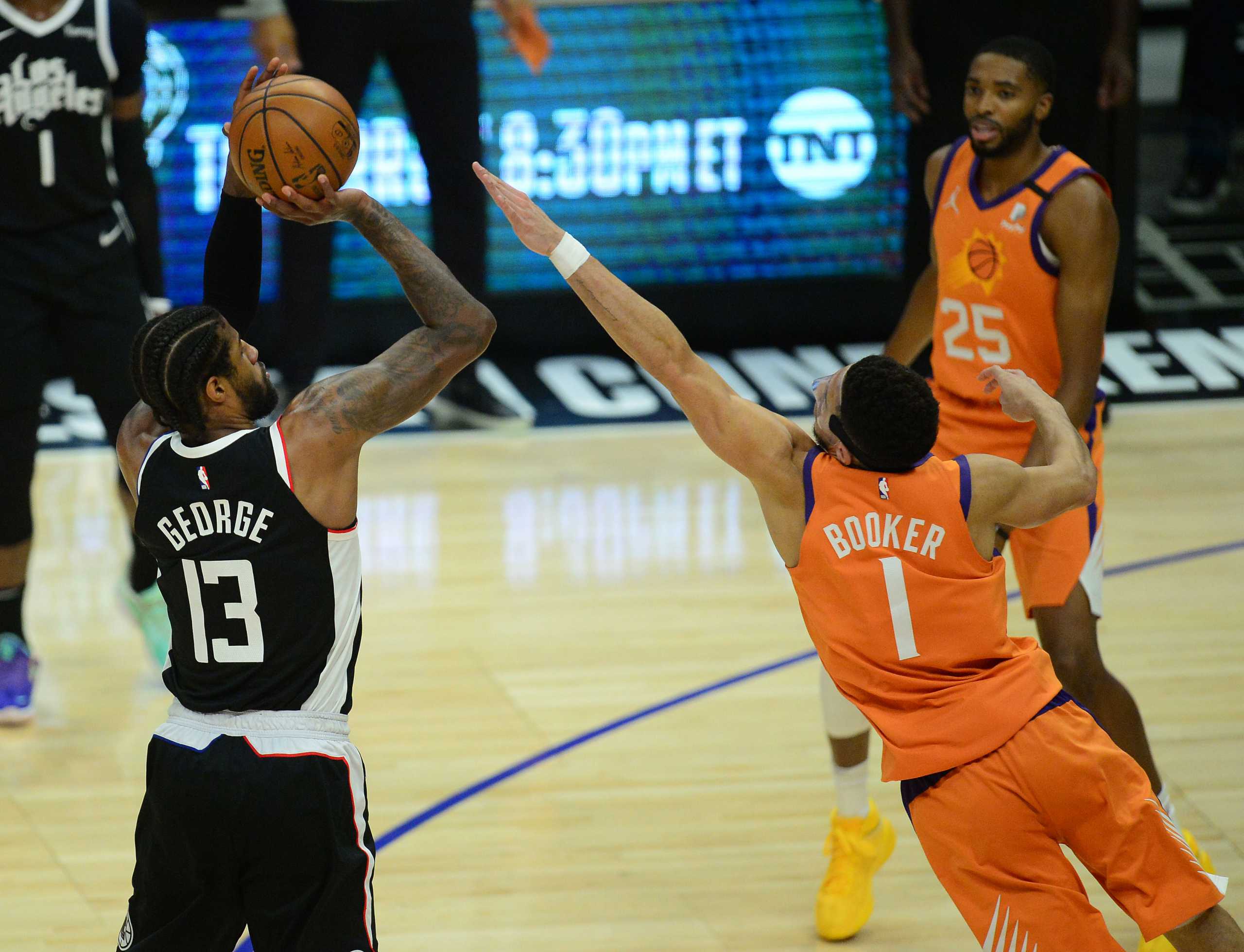 Jun 24, 2021; Los Angeles, California, USA; Los Angeles Clippers guard Paul George (13) shoots against Phoenix Suns guard Devin Booker (1) during the first half in game three of the Western Conference Finals for the 2021 NBA Playoffs at Staples Center. Mandatory Credit: Gary A. Vasquez-USA TODAY Sports