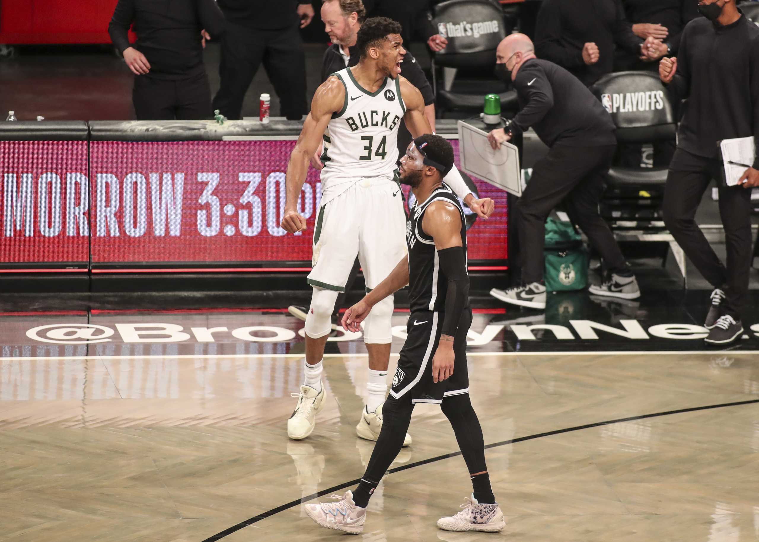 Jun 19, 2021; Brooklyn, New York, USA; Milwaukee Bucks forward Giannis Antetokounmpo (34) celebrates as Brooklyn Nets guard Bruce Brown (1) walks back to the bench after the Bucks won 115-111 in overtime in game seven in the second round of the 2021 NBA Playoffs at Barclays Center. Mandatory Credit: Wendell Cruz-USA TODAY Sports