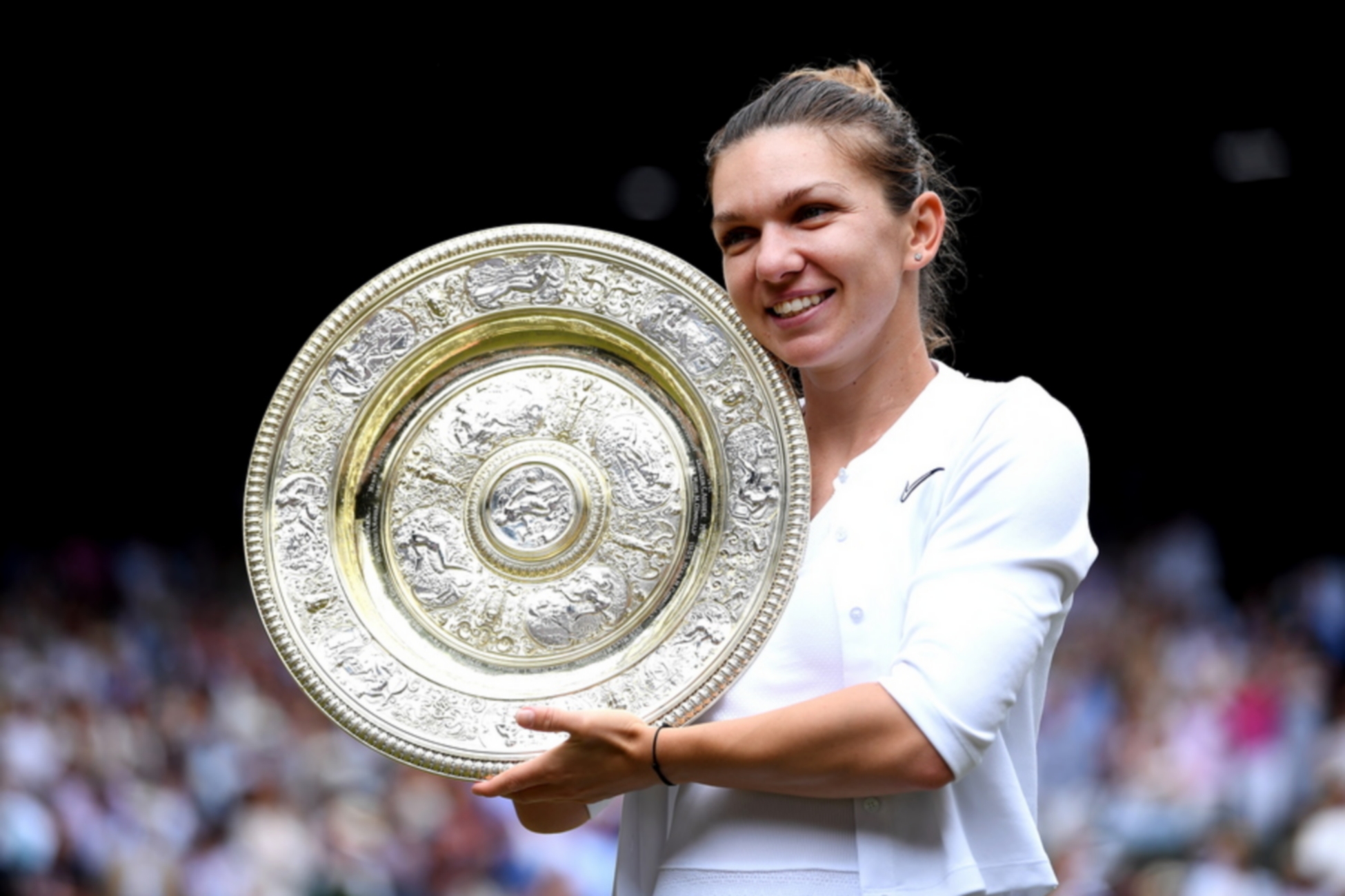 epa07714738 Simona Halep of Romania with the championship trophy as she celebrates her victory over Serena Williams of the US in the women's final of the Wimbledon Championships at the All England Lawn Tennis Club, in London, Britain, 13 July 2019. EPA
