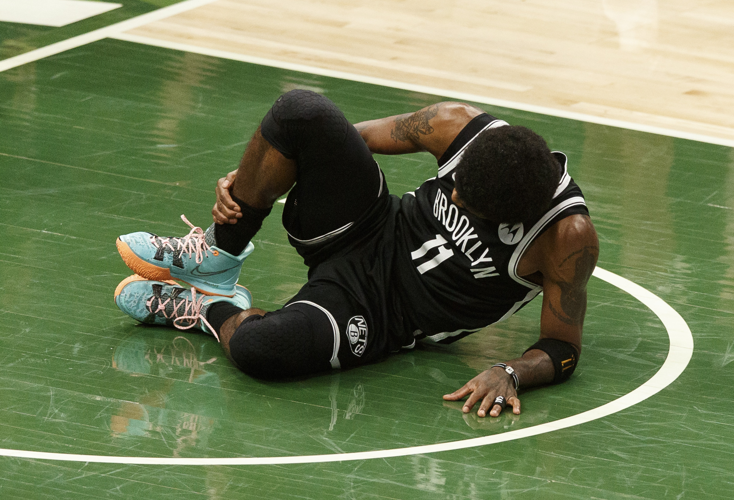 Jun 13, 2021; Milwaukee, Wisconsin, USA;  Brooklyn Nets guard Kyrie Irving (11) grabs his leg after being injured during the second quarter against the Milwaukee Bucks during game four in the second round of the 2021 NBA Playoffs. at Fiserv Forum. Mandatory Credit: Jeff Hanisch-USA TODAY Sports