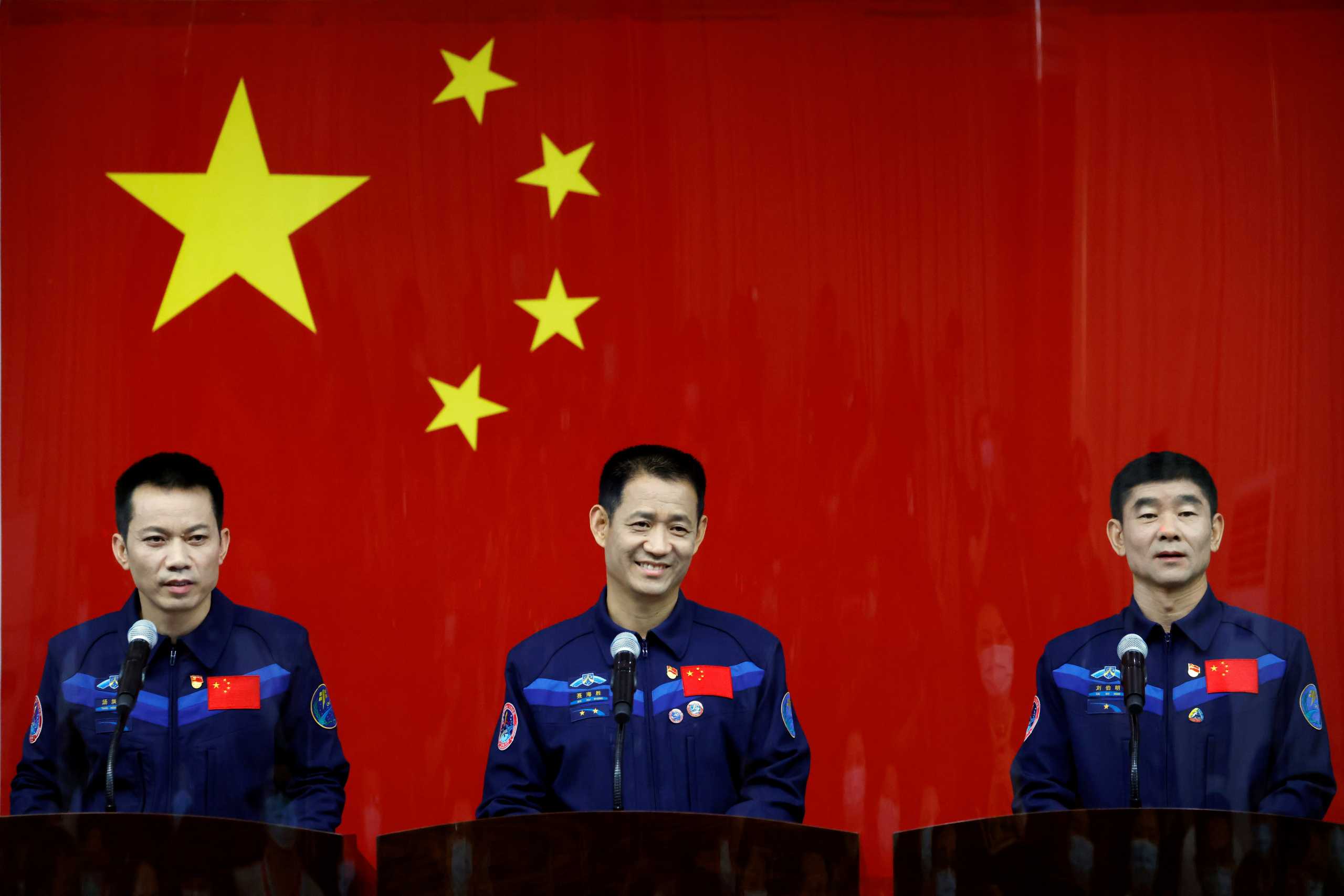 Chinese astronauts Nie Haisheng, Liu Boming, and Tang Hongbo meet members of the media behind a glass wall before the Shenzhou-12 mission to build China's space station, at Jiuquan Satellite Launch Center near Jiuquan, Gansu province, China June 16, 2021. REUTERS