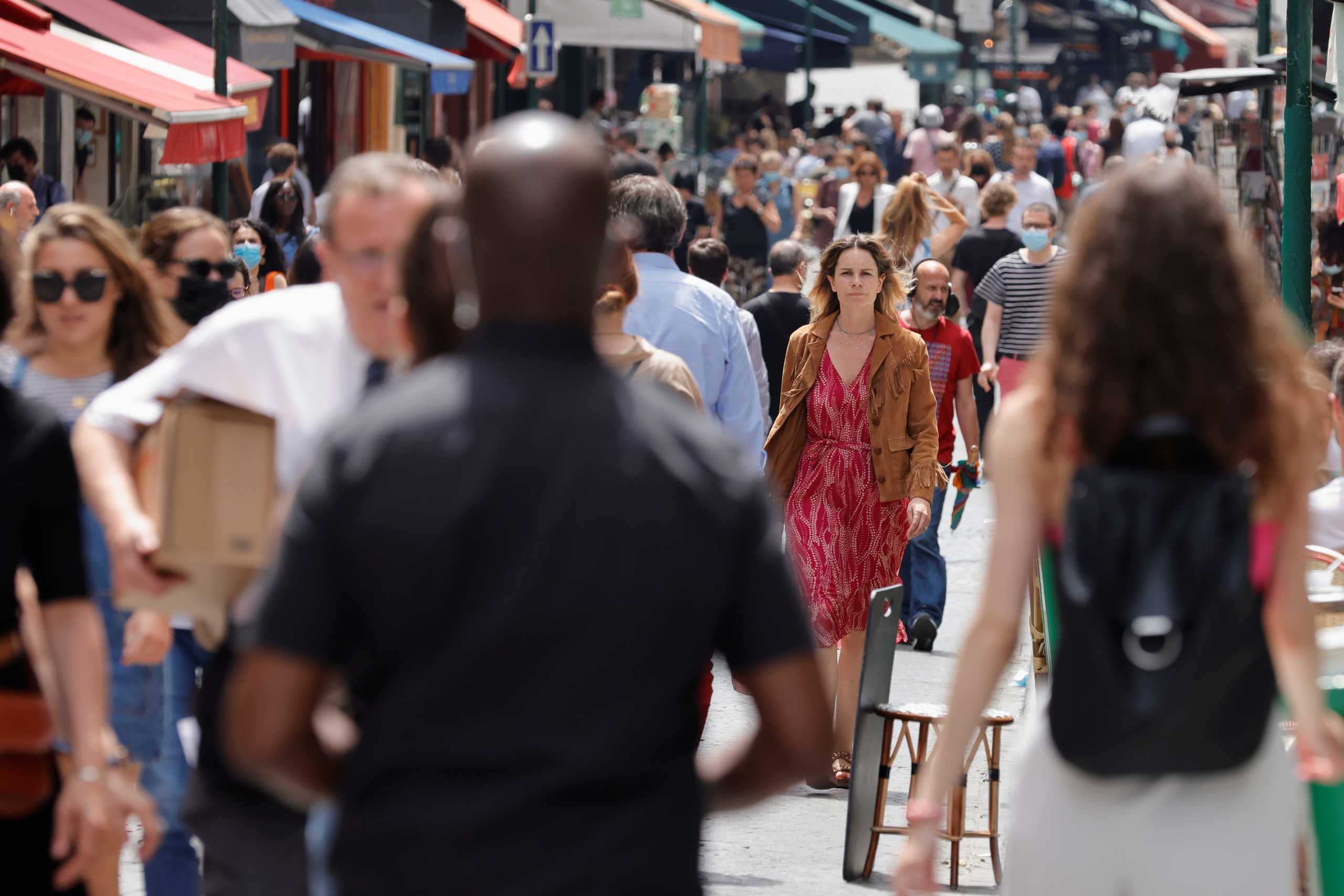 People walk without protective face masks as they are no longer required outdoors amid the coronavirus disease (COVID-19) pandemic, in Paris, France, June 17, 2021. REUTERS