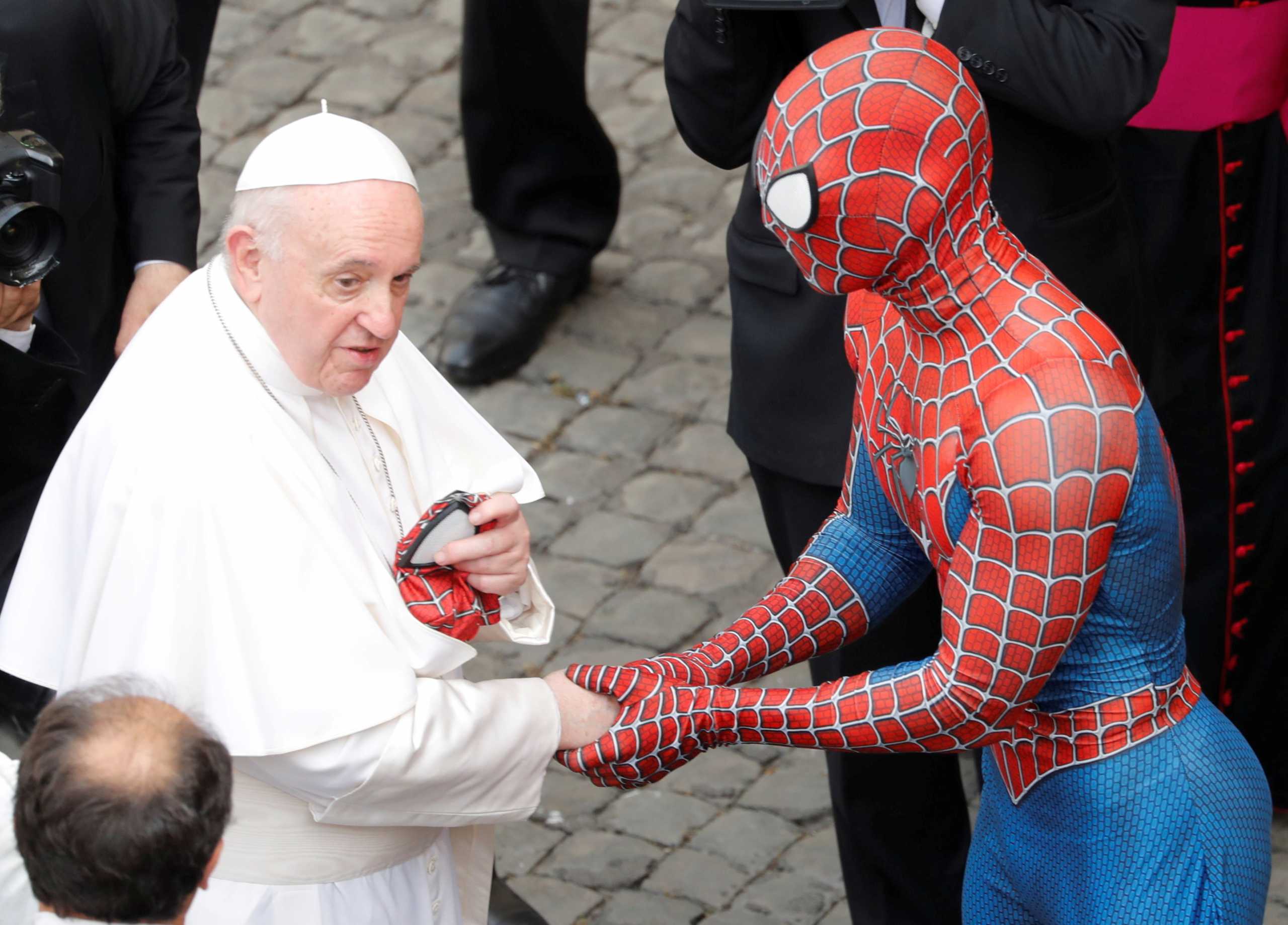 Pope Francis receives a Spider-Man mask from a person dressed as Spider-Man after the general audience, amid the coronavirus disease (COVID-19) pandemic, at the Vatican, June 23, 2021. REUTERS