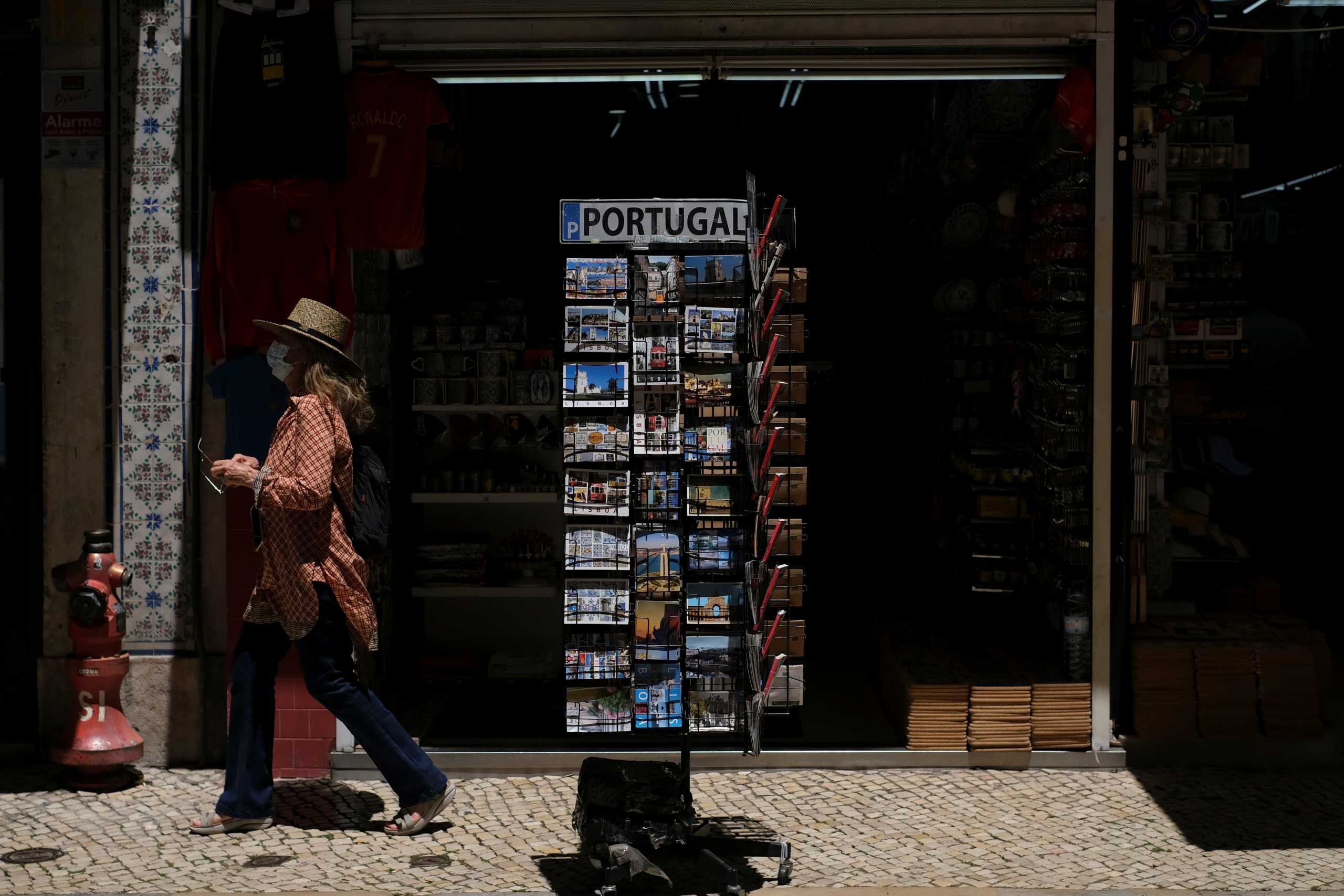 A woman wearing a protective mask walks in Lisbon downtown amid the coronavirus disease (COVID-19) pandemic, in Lisbon, Portugal, June 24, 2021. REUTERS