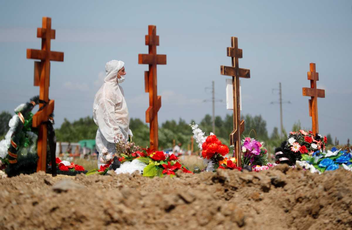 A grave digger wearing personal protective equipment (PPE) as a preventive measure against the coronavirus disease (COVID-19) buries a person at a graveyard on the outskirts of Saint Petersburg, Russia June 25, 2021. REUTERS