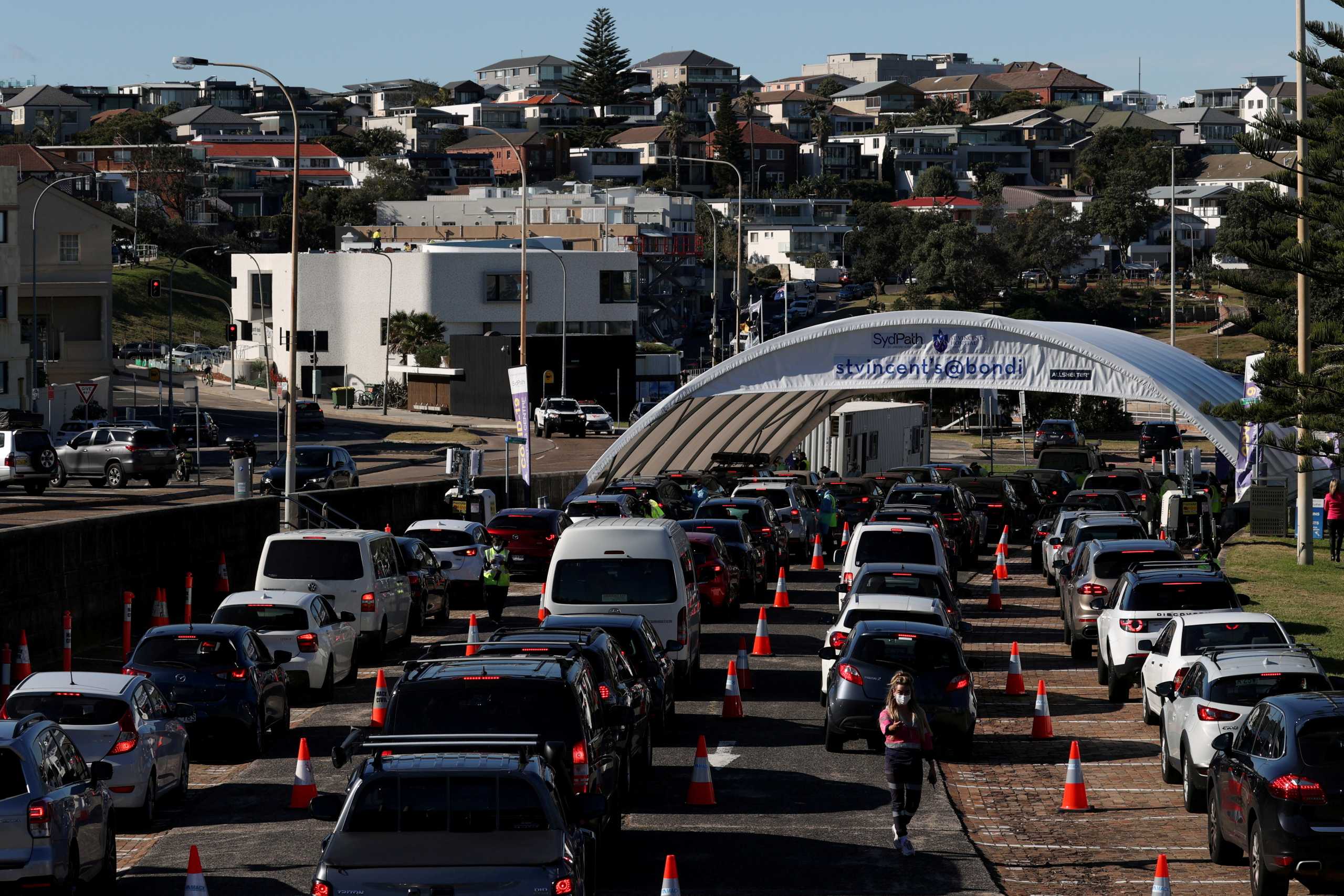 FILE PHOTO: Vehicles wait in line at the Bondi Beach drive-through coronavirus disease (COVID-19) testing centre in the wake of new positive cases in Sydney, Australia, June 17, 2021.  REUTERS