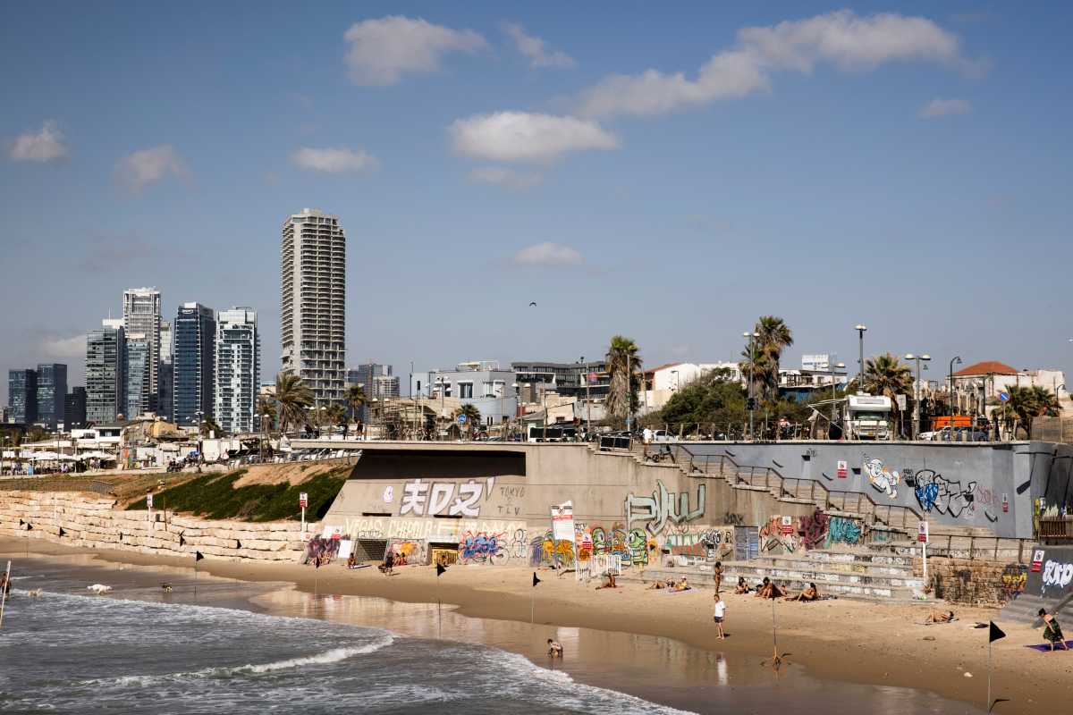People visit a beach as towers in Tel Aviv are seen in the background, in Jaffa, Israel May 23, 2021. Picture taken May 23, 2021. REUTERS