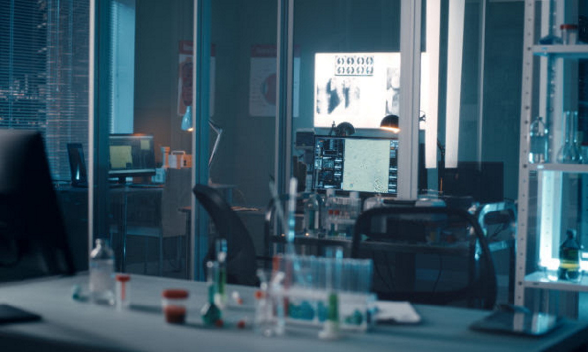 Desk with various vaccine samples located inside dark modern lab during coronavirus pandemic
