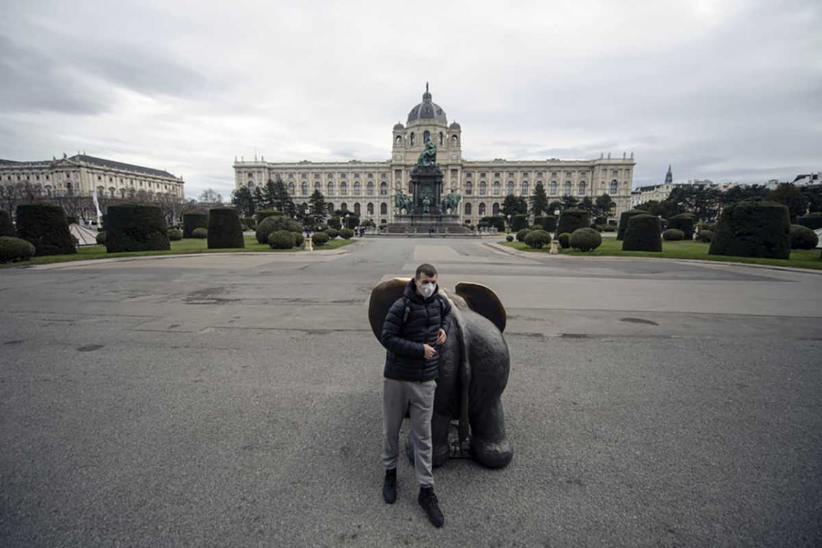 epa08285840 A man wearing a protective mask poses for photographs, with the closed Museum of Art History (KHM Kunsthistorisches Museum) in the background, in Vienna, Austria, 11 March 2020. In an attempt to stop the spreading of the novel coronavirus related Covid-19 disease, Austrian Chancellor announced on 10 March to close all state museums, the Vienna State Opera and other federal buildings. All public indoor gatherings with over 100 people and outdoor gatherings with 500 people have been banned and the population has been advised to reduce their social contacts.  EPA