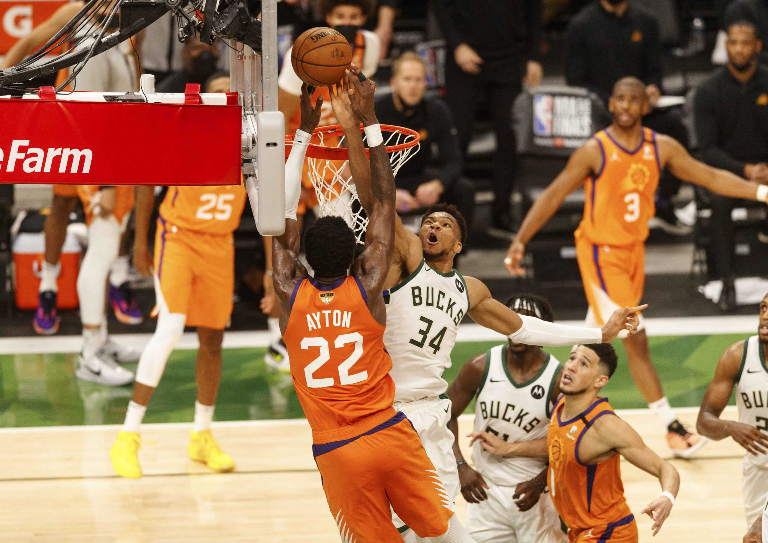 Jul 14, 2021; Milwaukee, Wisconsin, USA; Milwaukee Bucks forward Giannis Antetokounmpo (34) defends Phoenix Suns center Deandre Ayton (22) during the fourth quarter during game four of the 2021 NBA Finals at Fiserv Forum. Mandatory Credit: Jeff Hanisch-USA TODAY Sports