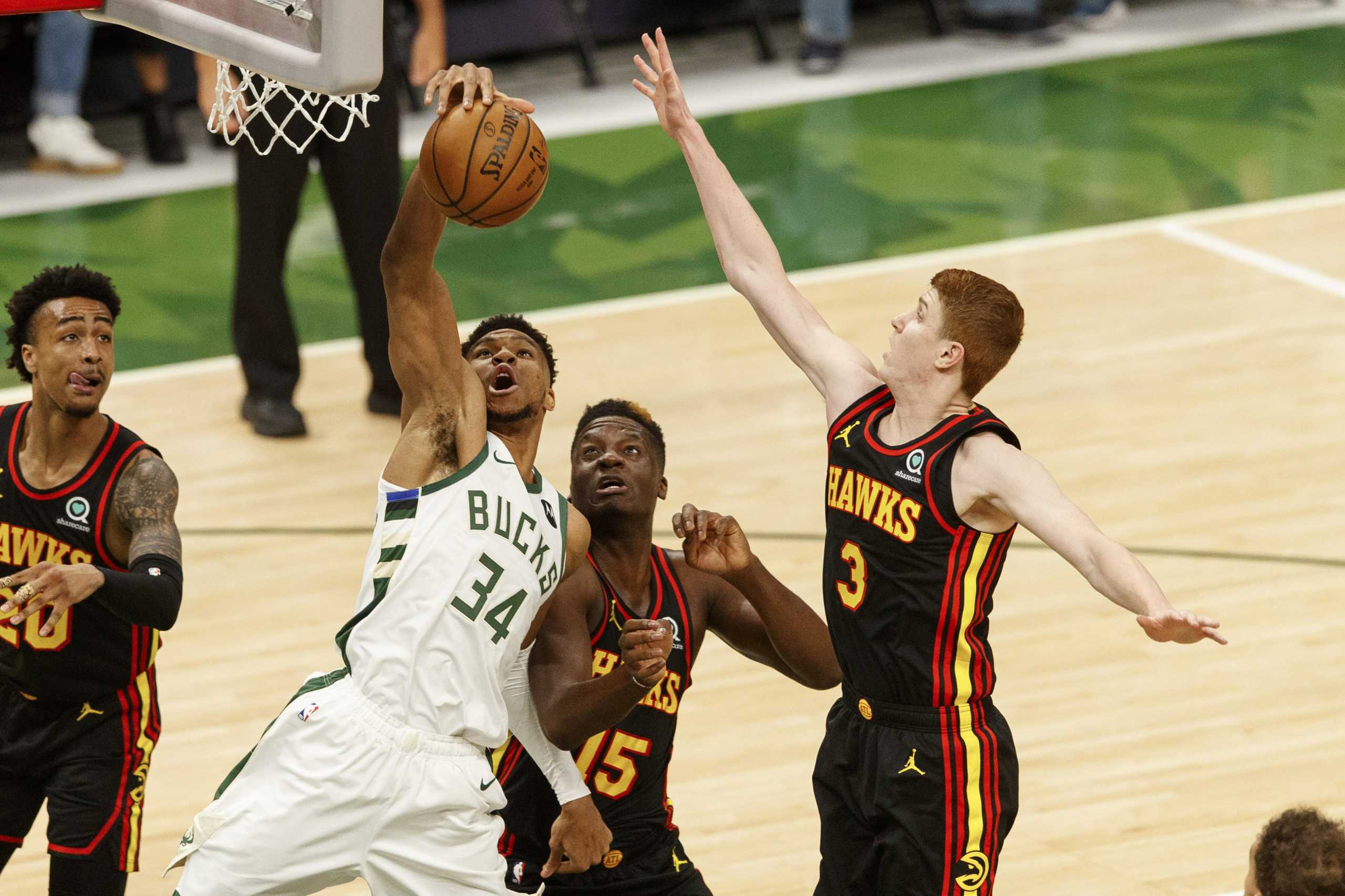 Jun 25, 2021; Milwaukee, Wisconsin, USA; Milwaukee Bucks forward Giannis Antetokounmpo (34) grabs a rebound in front of Atlanta Hawks center Clint Capela (15) and jguard Kevin Huerter (3) during the first quarter of game two of the Eastern Conference Finals for the 2021 NBA Playoffs at Fiserv Forum. Mandatory Credit: Jeff Hanisch-USA TODAY Sports