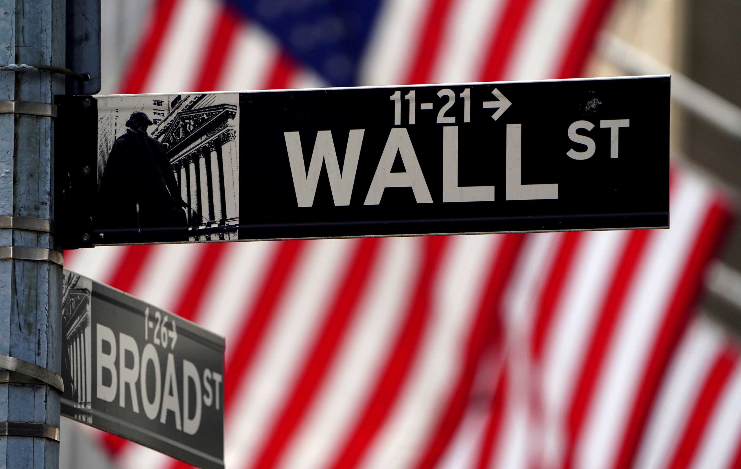 FILE PHOTO: A Wall Street sign is pictured outside the New York Stock Exchange amid the coronavirus disease (COVID-19) pandemic in the Manhattan borough of New York City, New York, U.S., April 16, 2021. REUTERS