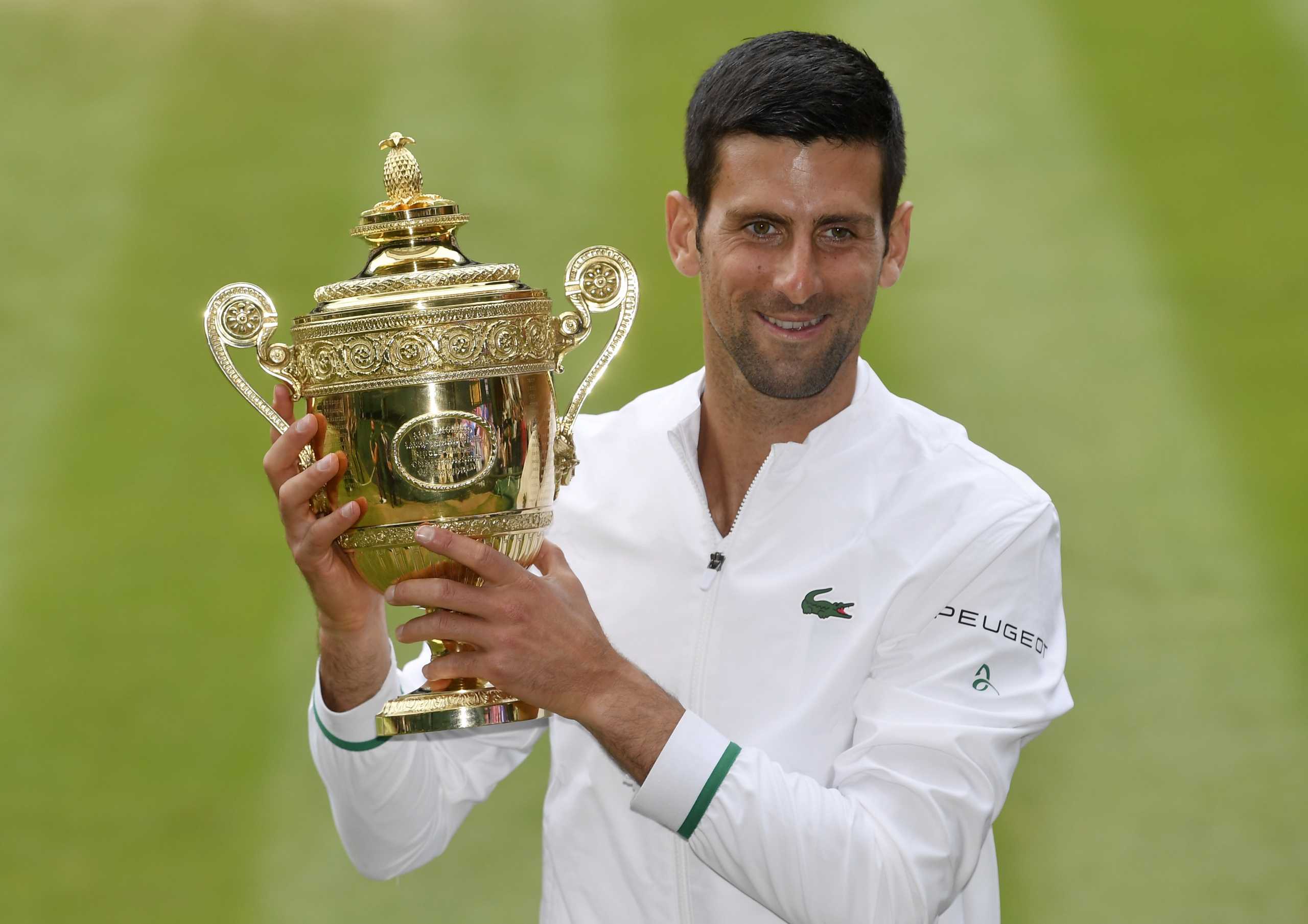 Tennis - Wimbledon - All England Lawn Tennis and Croquet Club, London, Britain - July 11, 2021 Serbia's Novak Djokovic celebrates with the trophy after winning his final match against Italy's Matteo Berrettini REUTERS