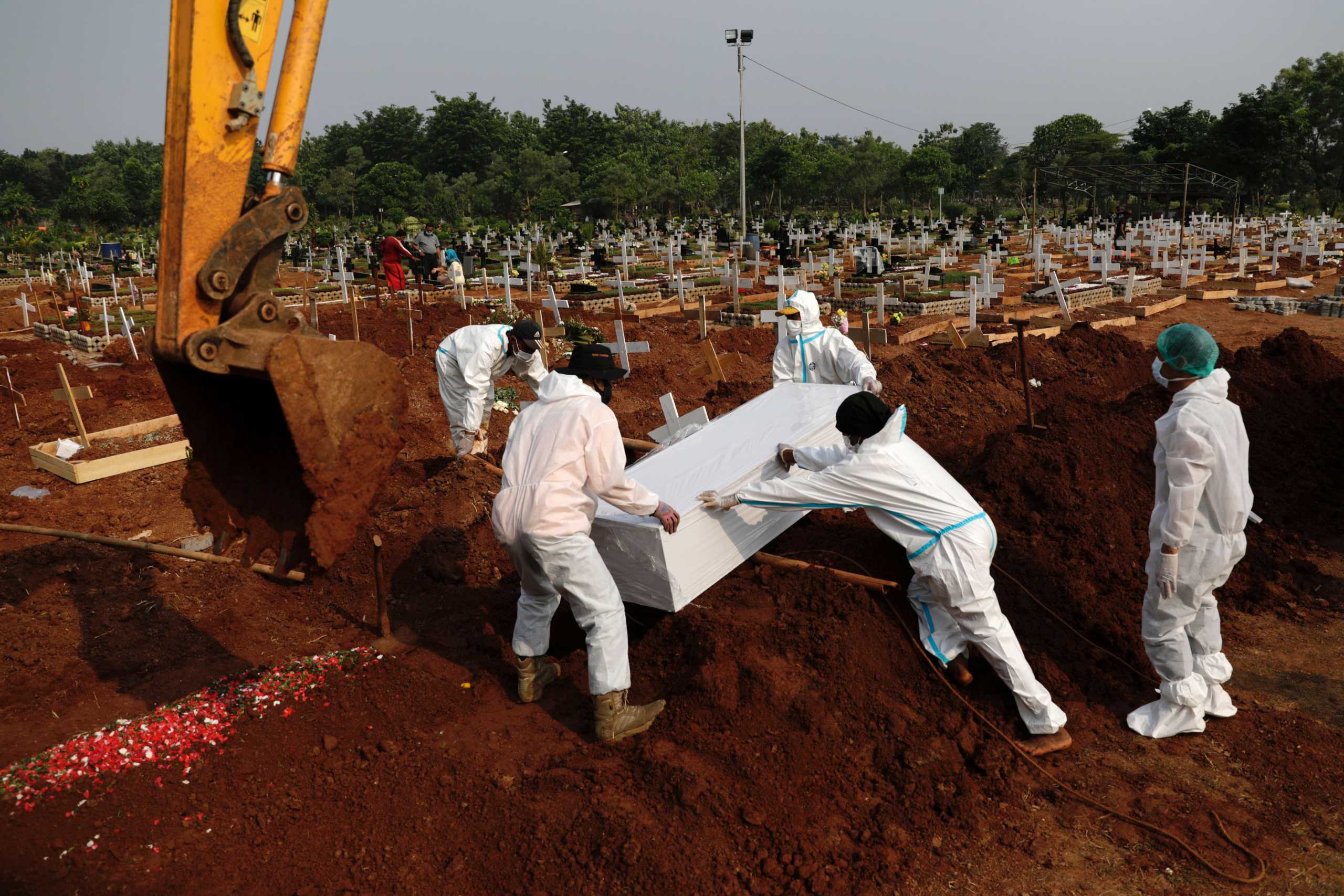 Workers wearing Personal Protective Equipments (PPE) burry the coffin of 72-year-old man who passed away due to coronavirus disease (COVID-19) at a burial area provided by the government for COVID-19 victims as the case surges, in Bekasi, on the outskirts of Jakarta, Indonesia, July 15, 2021. REUTERS