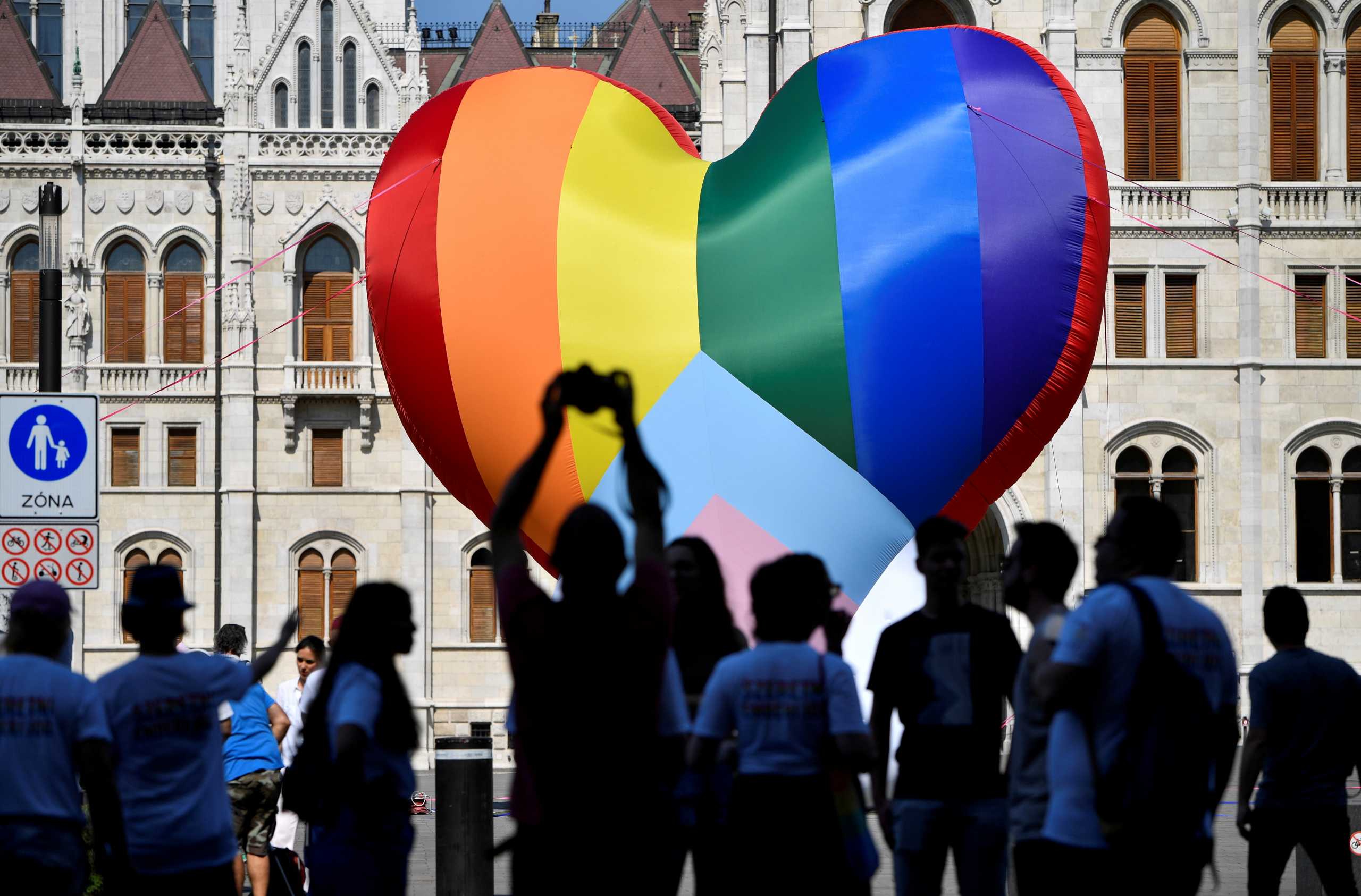 FILE PHOTO: People gather in front of a huge rainbow balloon put up by members of Amnesty International and Hatter, an NGO promoting LGBT rights, at Hungary's parliament in Budapest, Hungary, July 8, 2021. REUTERS