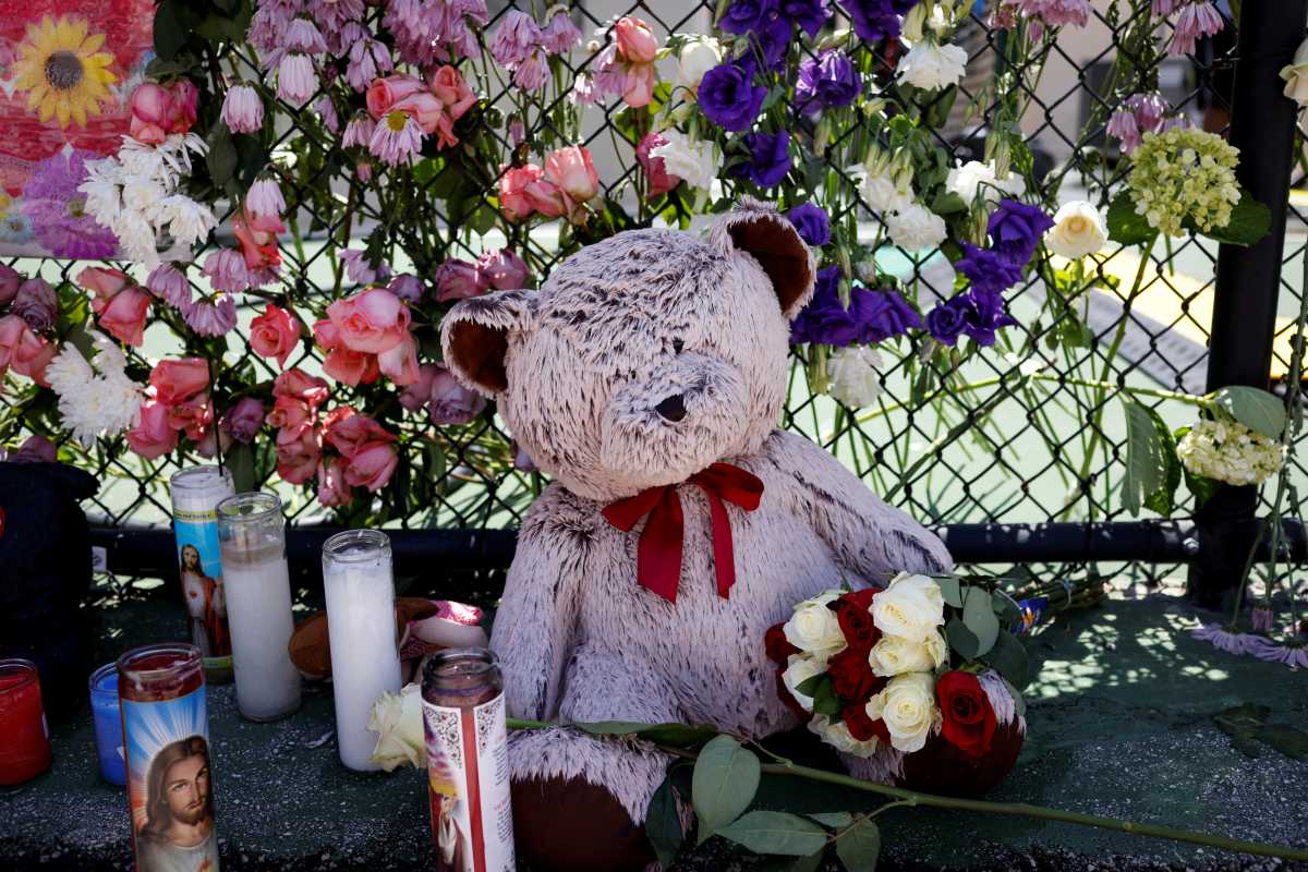 Toys and flowers hang on a fence at the memorial for victims of a partially collapsed residential building as the emergency crews continue the search and rescue operations for survivors, in Surfside, near Miami Beach, Florida, U.S. July 2, 2021. REUTERS