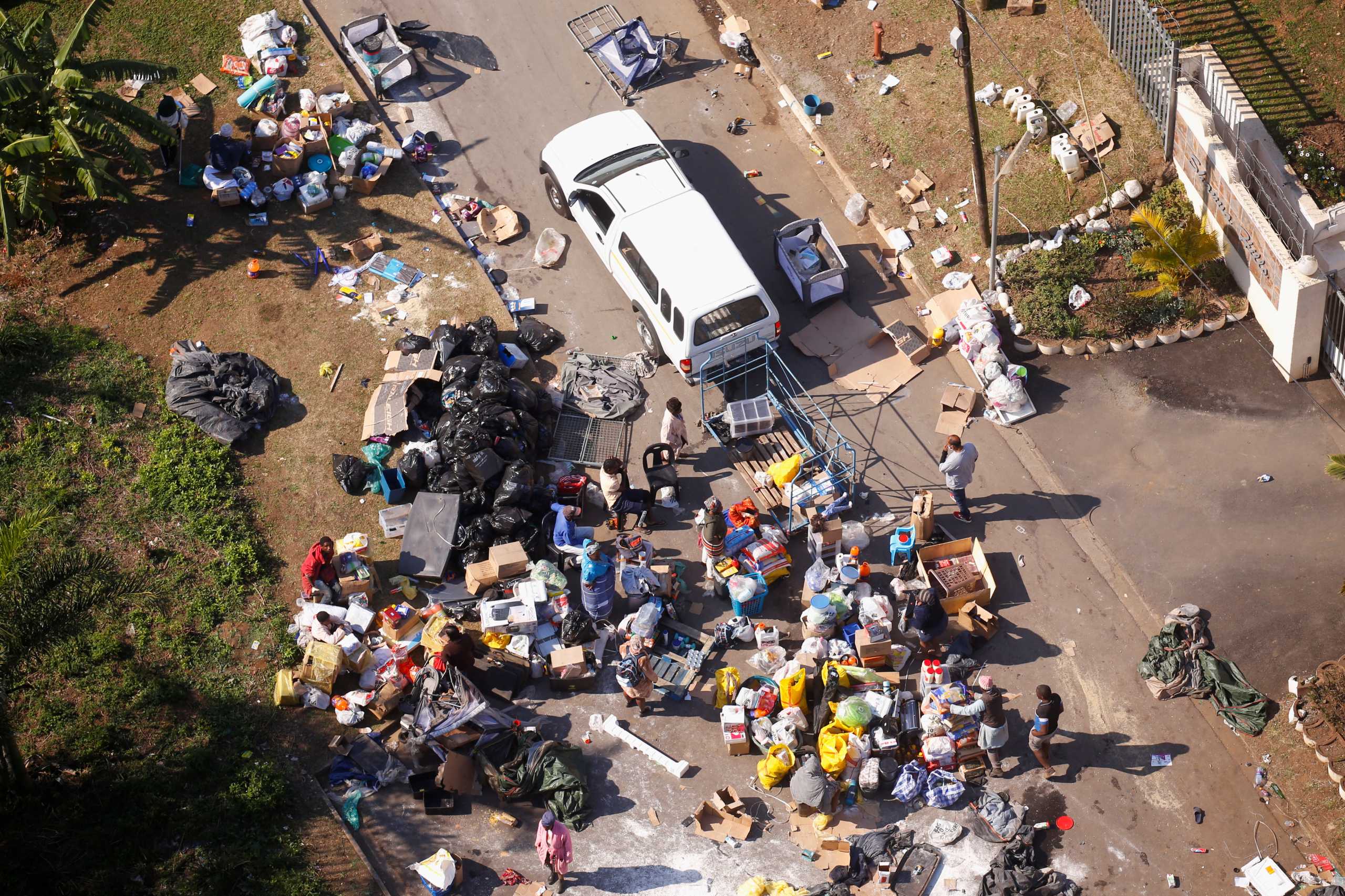 People loot an area near a burning warehouse after violence erupted following the jailing of former South African President Jacob Zuma, in Durban, South Africa, July 14, 2021. REUTERS