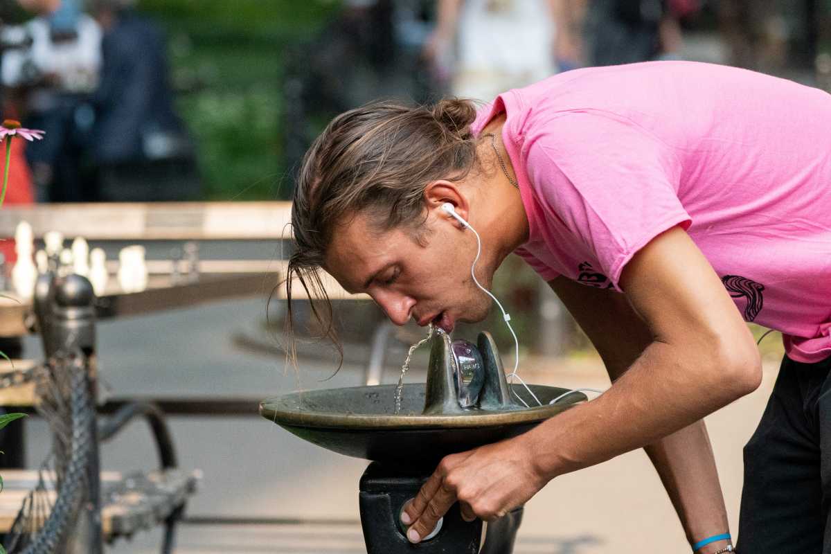 A man drinks from a water fountain in Washington Square park during a heat wave in New York City, New York, U.S., July 6, 2021. REUTERS