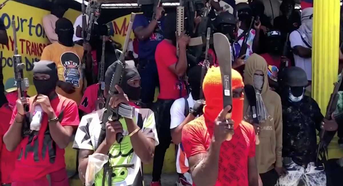 Gang members wielding machetes and guns stand in formation in Port-au-Prince, Haiti June 23, 2021. in this screen grab taken from a video. Video recorded June 23, 2021. REUTERS