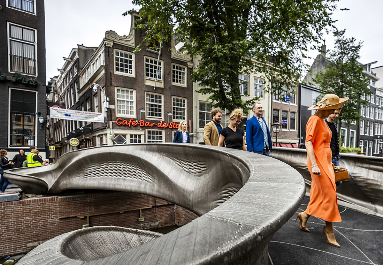 epa09345712 Dutch Queen Maxima (R) opens a 3D-printed bridge on the Oudezijds Achterburgwal in Amsterdam, The Netherlands, 15 July 2021. The steel pedestrian bridge has smart sensors that measure traffic flows, crowds and temperature, among other things.  EPA