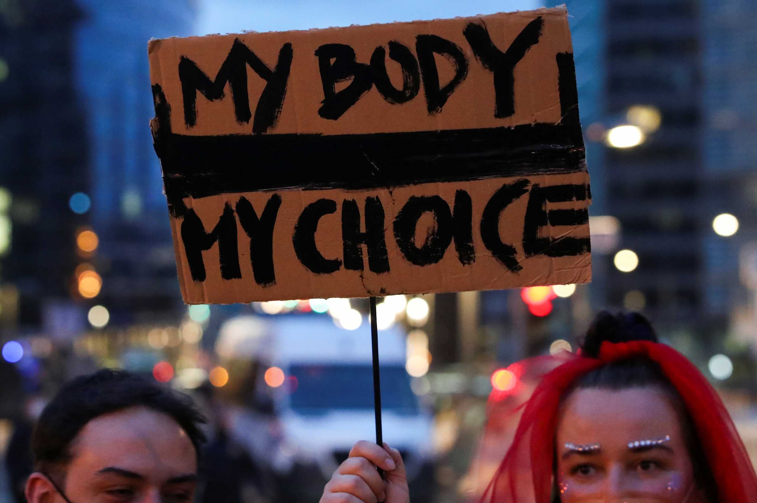 FILE PHOTO: A person holds a sign during a protest against the ruling by Poland's Constitutional Tribunal that imposes a near-total ban on abortion, outside the EU headquarters in Brussels, Belgium November 11, 2020. REUTERS