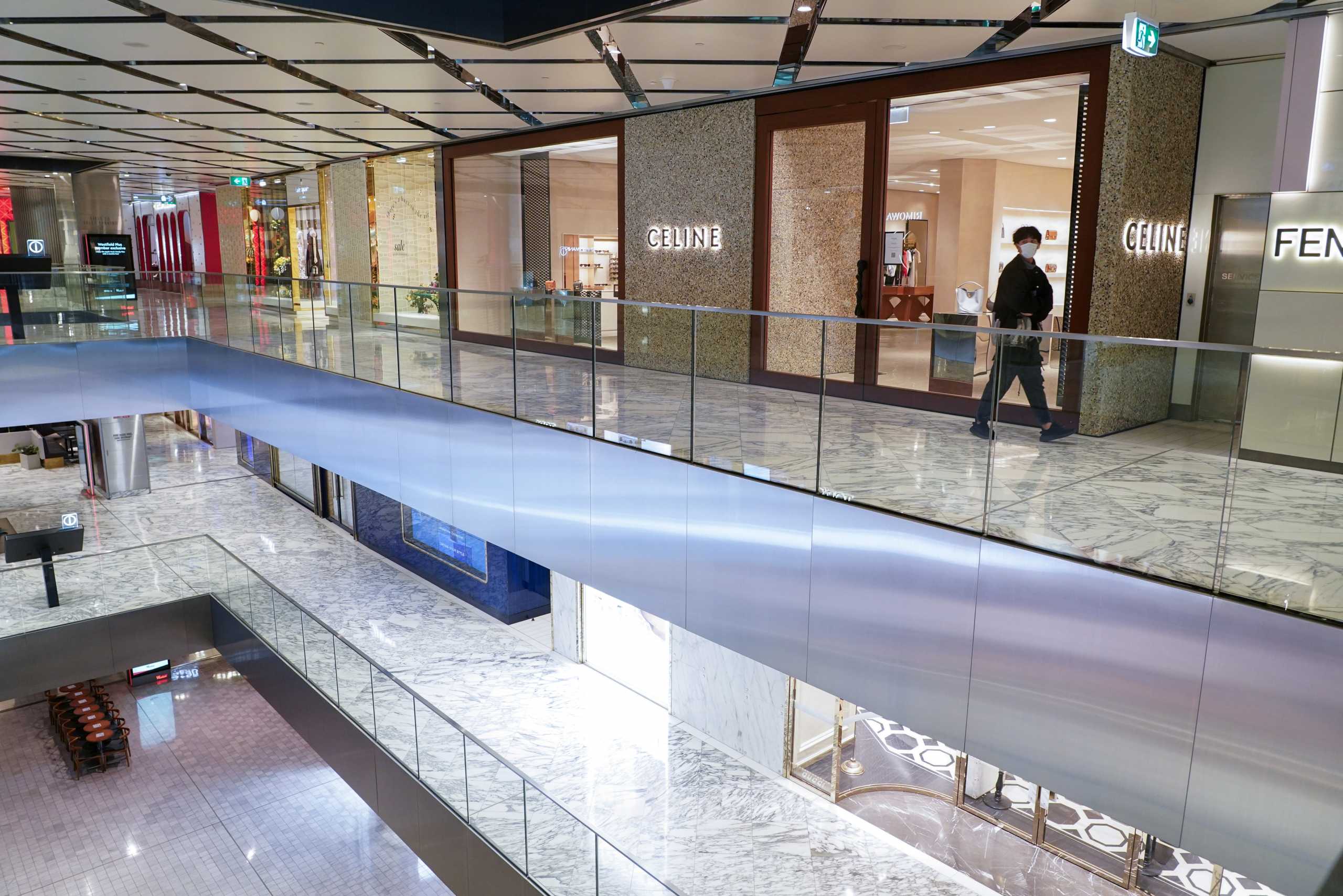 A lone man wearing a protective face mask walks through a city centre shopping mall mostly empty of people during a lockdown to curb the spread of a coronavirus disease (COVID-19) outbreak in Sydney, Australia, July 14, 2021.  REUTERS