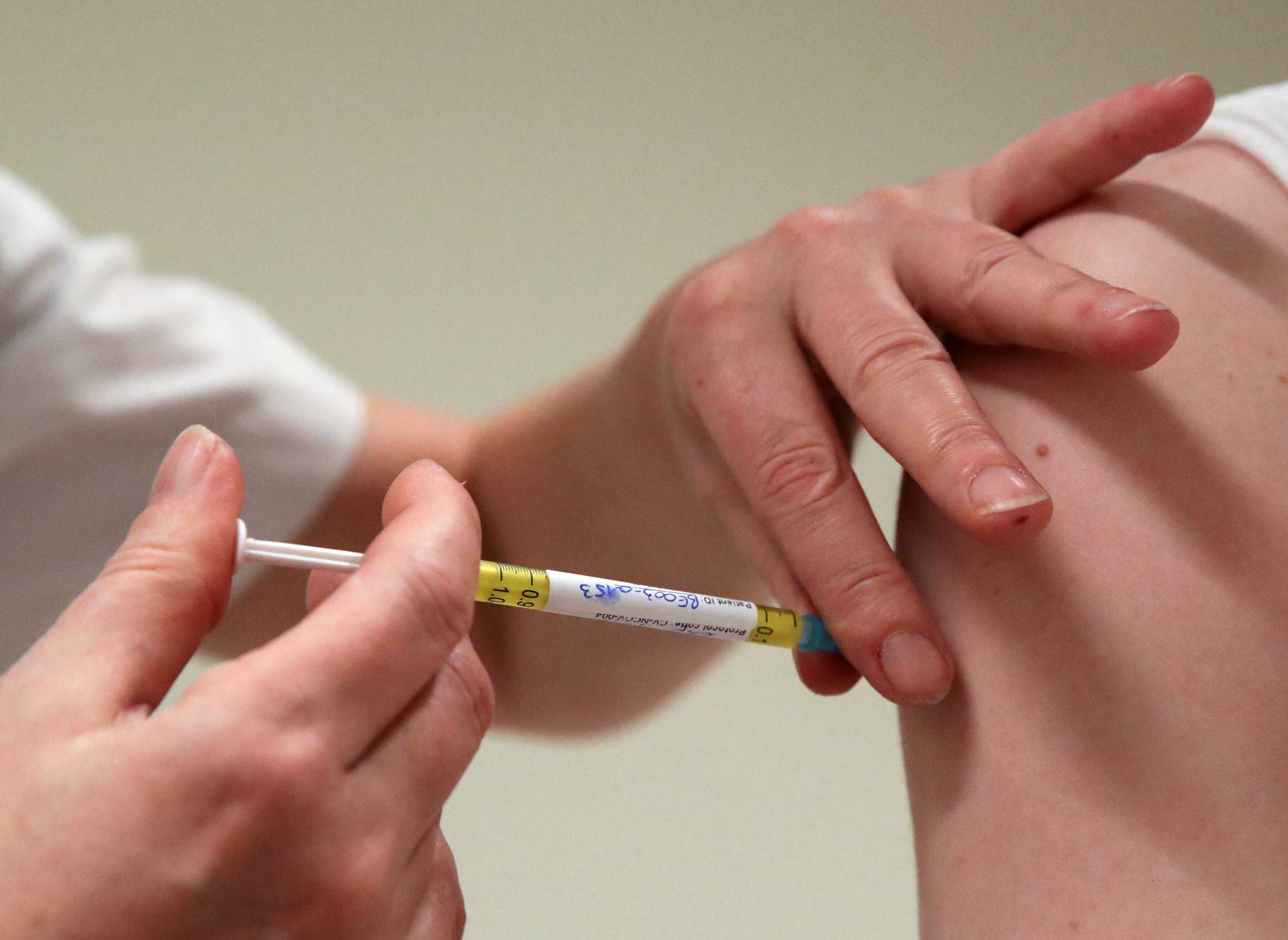 FILE PHOTO: A volunteer receives a dose of CureVac vaccine or a placebo during a study by the German biotech firm CureVac as part of a testing for a new vaccine against the coronavirus disease (COVID-19), in Brussels, Belgium March 2, 2021. REUTERS