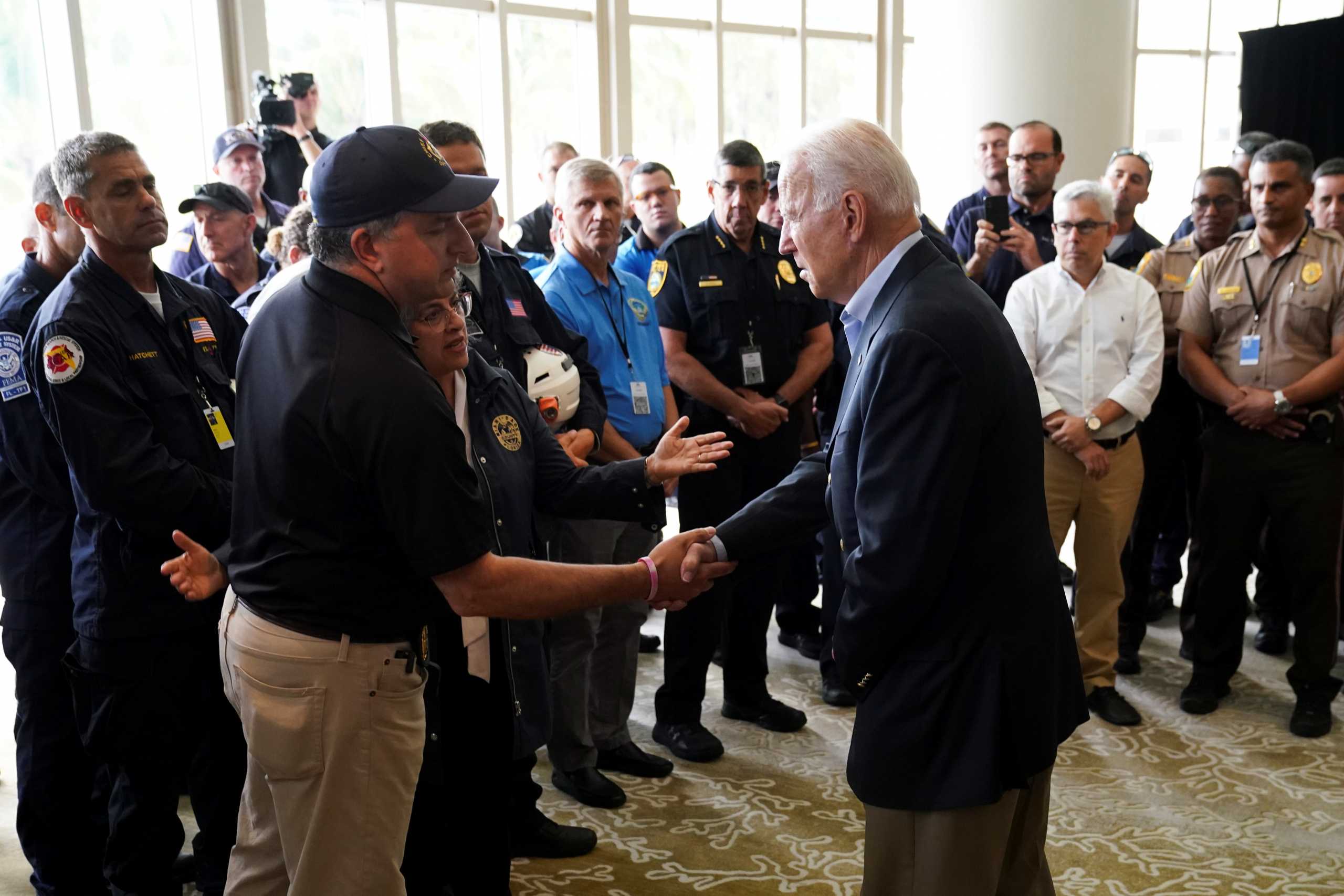 U.S. President Joe Biden shakes hands with Florida Chief Financial Officer Jimmy Patronis as he meets rescue teams and first responders on the building collapse in Surfside in Miami, Florida U.S., July 1, 2021. REUTERS