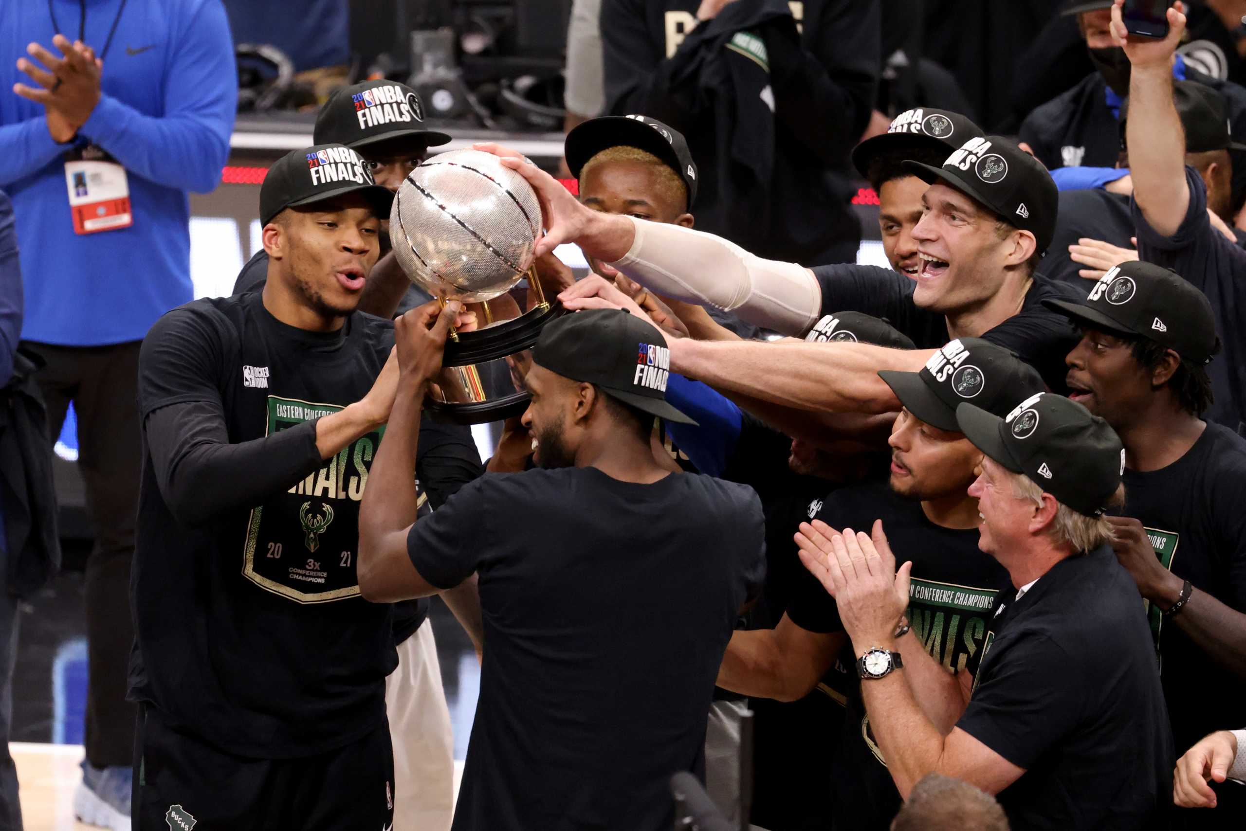 Jul 3, 2021; Atlanta, Georgia, USA; Milwaukee Bucks forward Khris Middleton (22) holds up the Eastern Conference Finals Trophy and celebrates with teammates after the Bucks defeated the Atlanta Hawks in game six of the Eastern Conference Finals for the 2021 NBA Playoffs at State Farm Arena. Mandatory Credit: Jason Getz-USA TODAY Sports