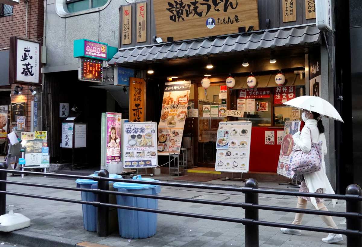 A woman walks past a restaurant near the Olympic stadium ahead of the Tokyo 2020 Olympic Games that have been postponed to 2021 due to the coronavirus disease (COVID-19) pandemic in Tokyo, Japan, July 16, 2021. REUTERS