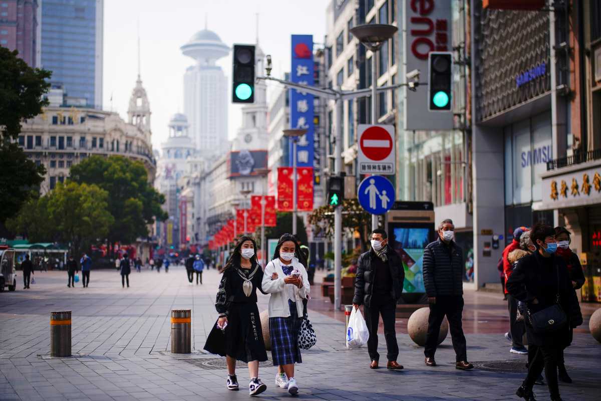 FILE PHOTO: FILE PHOTO: People wearing face masks walk at a main shopping area, following the coronavirus disease (COVID-19) outbreak in Shanghai, China January 27, 2021. REUTERS